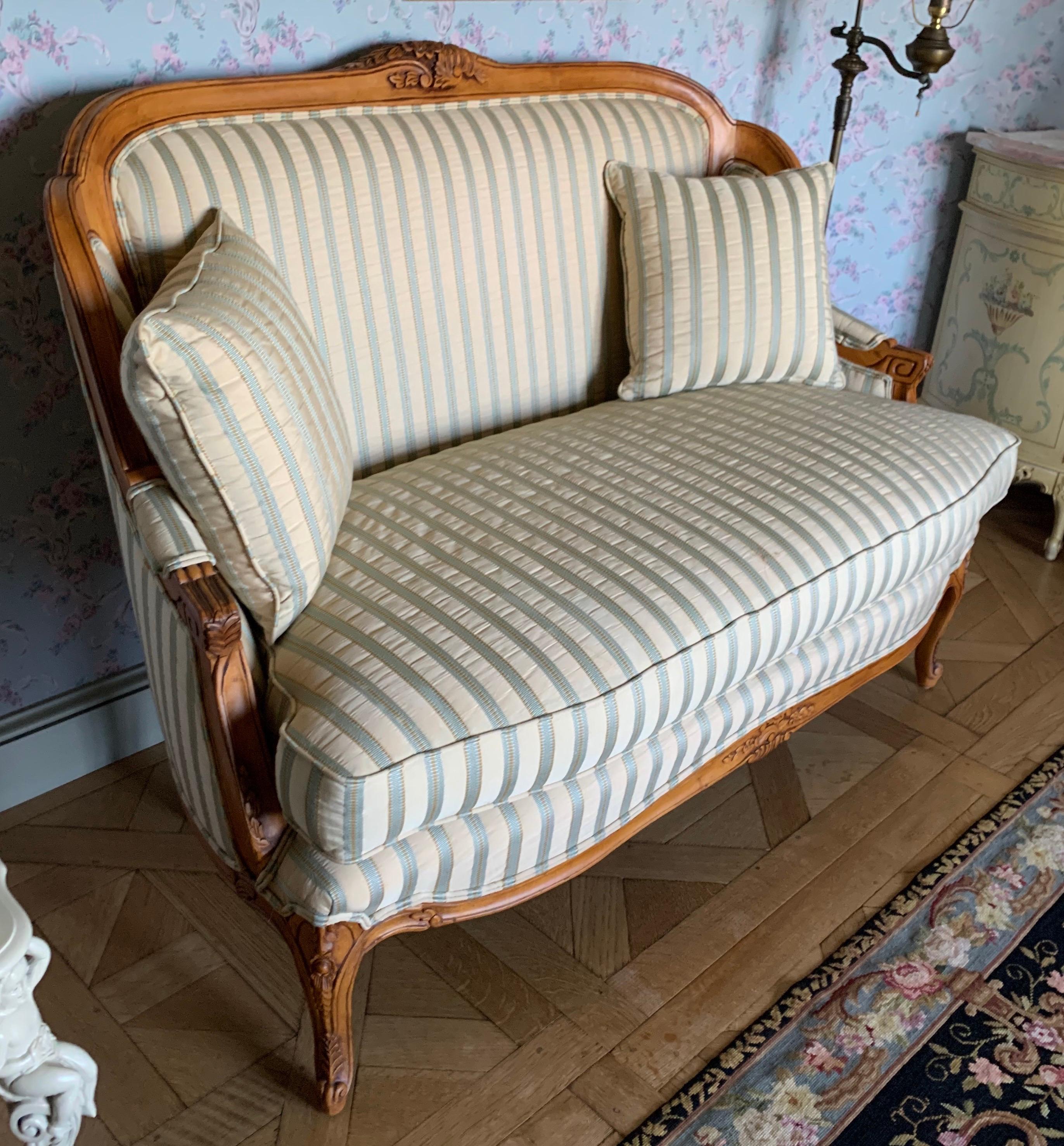 French carved beechwood loveseat with new striped silk upholstery in teal blue and gold. Features intricate carvings on the crest, arms and legs. Comes with two throw pillows. Custom piece of Farifield Furniture in Lenor, N.C., USA.