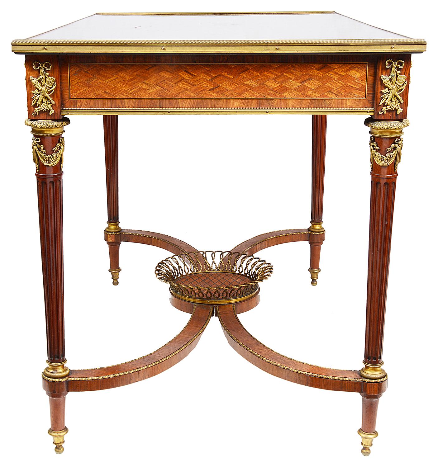 A very good quality French late 19th century inlaid centre table, the top having geometric parquetry inlay to the top and frieze, gilded ormolu mask and floral mounts, a single frieze drawer, stamped 'Shoolbred & Co' retailers. Further classical