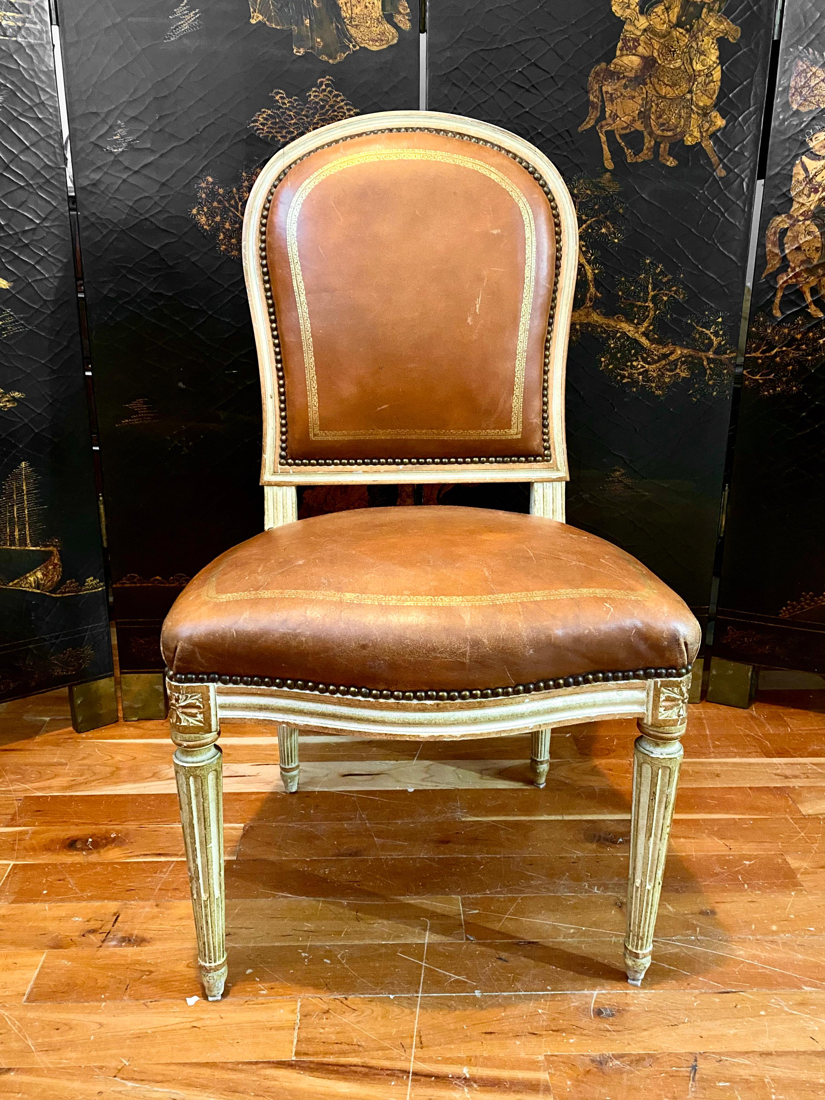French Louis XVI style chair, tooled and gilt leather. 
White-lacquered chair atop four tapered, fluted legs, based on a horse shoe-shaped model by Georges Jacob, famed seat maker to King Louis XVI. Georges Jacob was one of the two most prominent