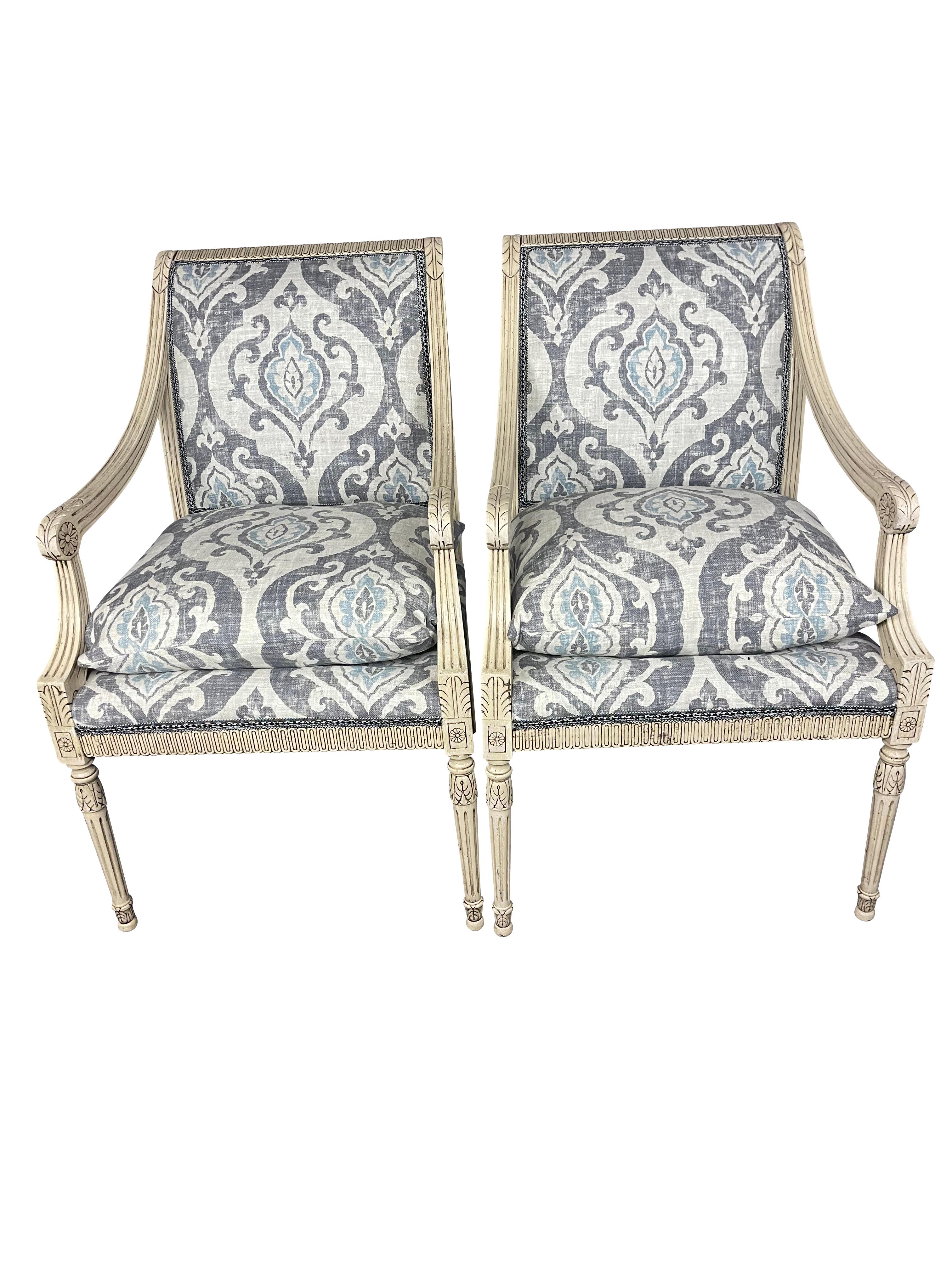 Ravissante paire de chaises de style Louis XVI, sculptées et peintes en gris, récemment retapissées par des professionnels dans un joli lin Ikat belge gris/bleu au design moderne. Les chaises sont amplement larges et confortables, avec une assise en