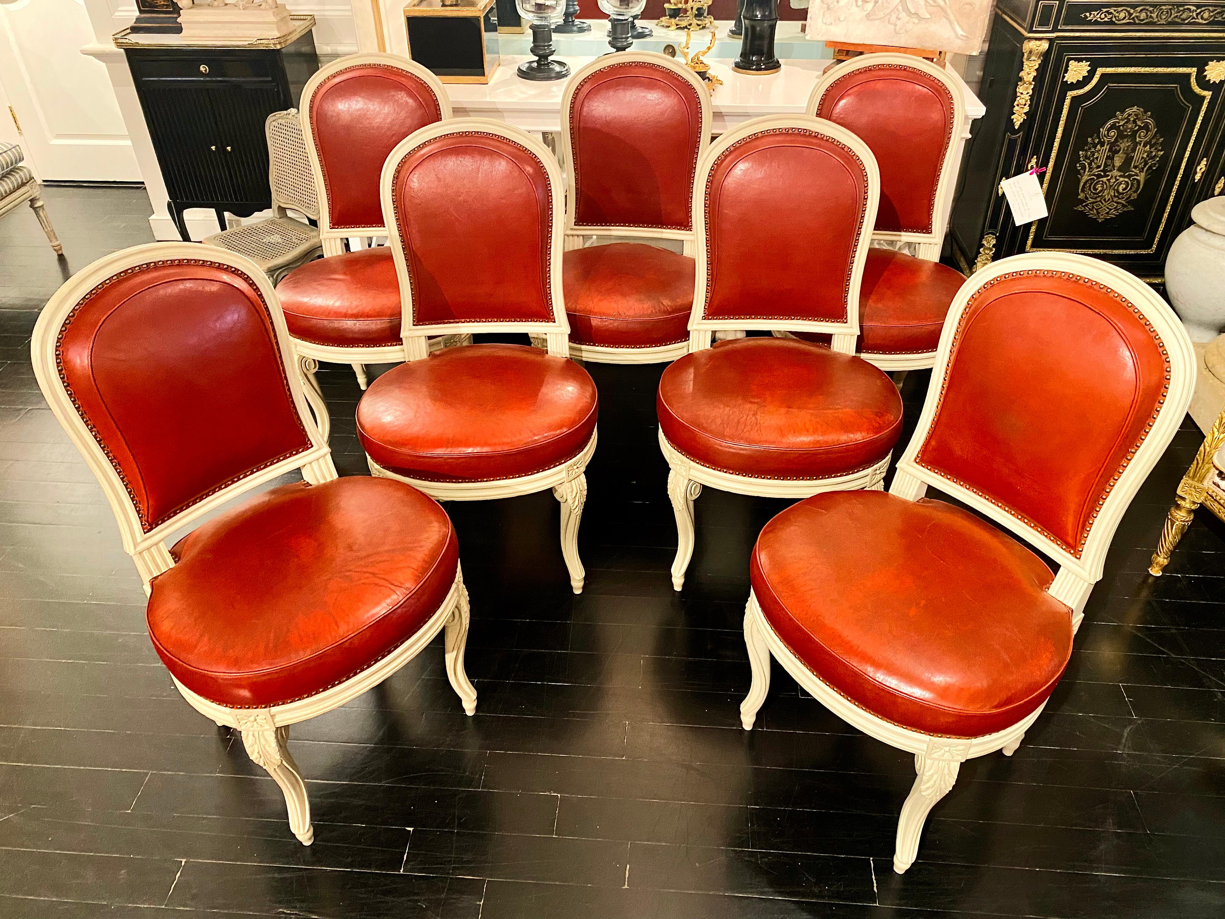 French Louis XVI Style chairs in the manner of Jacob, Possibly Maison Jansen.

Exceptional set of seven white patinated chairs in the manner of Georges Jacob, with buttery soft leather upholstery in an exquisite dark red tone. Mid-Century Modern