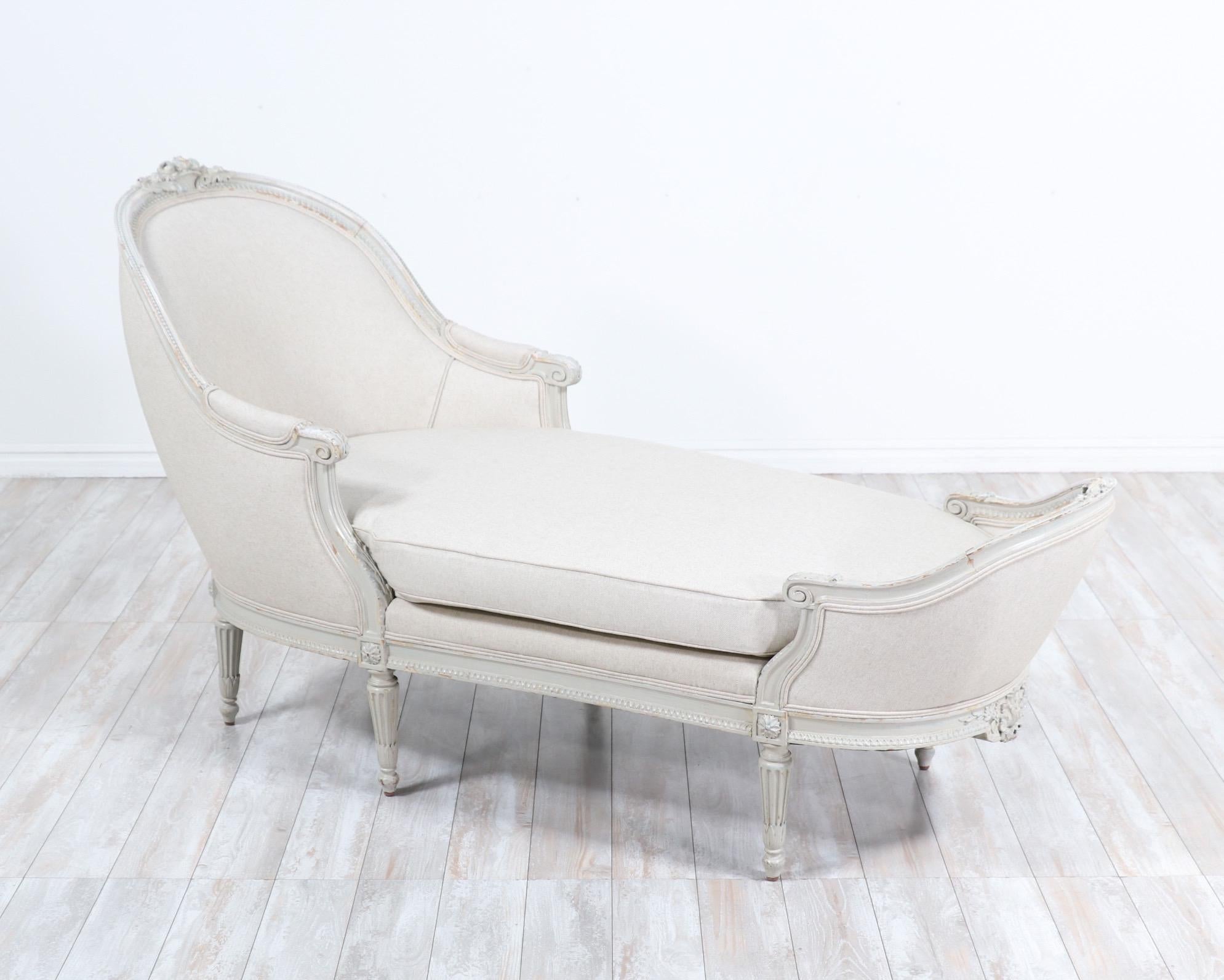 Glorious, 1920s French “duchesse en bateau” chaise lounge in the Louis XVI style. 

This exquisite chaise features detailed carved decorations throughout, a beautiful naturally distressed paint finish showing layers of old paint and new cotton linen