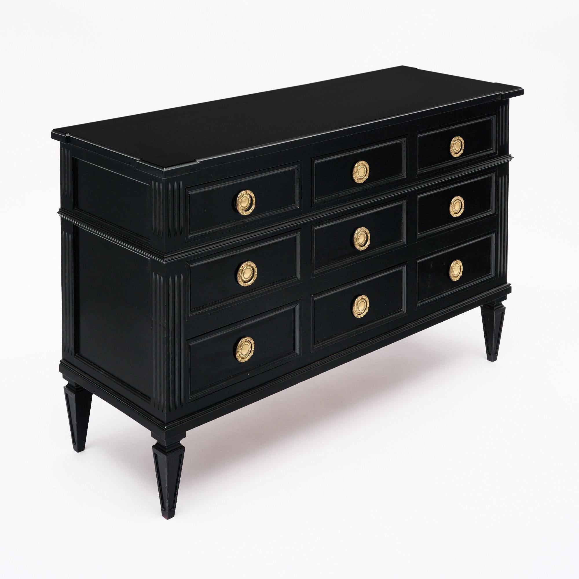 Cassettiera o commode in stile Luigi XVI. Questa cassapanca è realizzata in legno massiccio di ciliegio ebanizzato e rifinito con una lucentezza da museo di qualità francese. Questo elegante mobile neoclassico presenta nove cassetti a coda di
