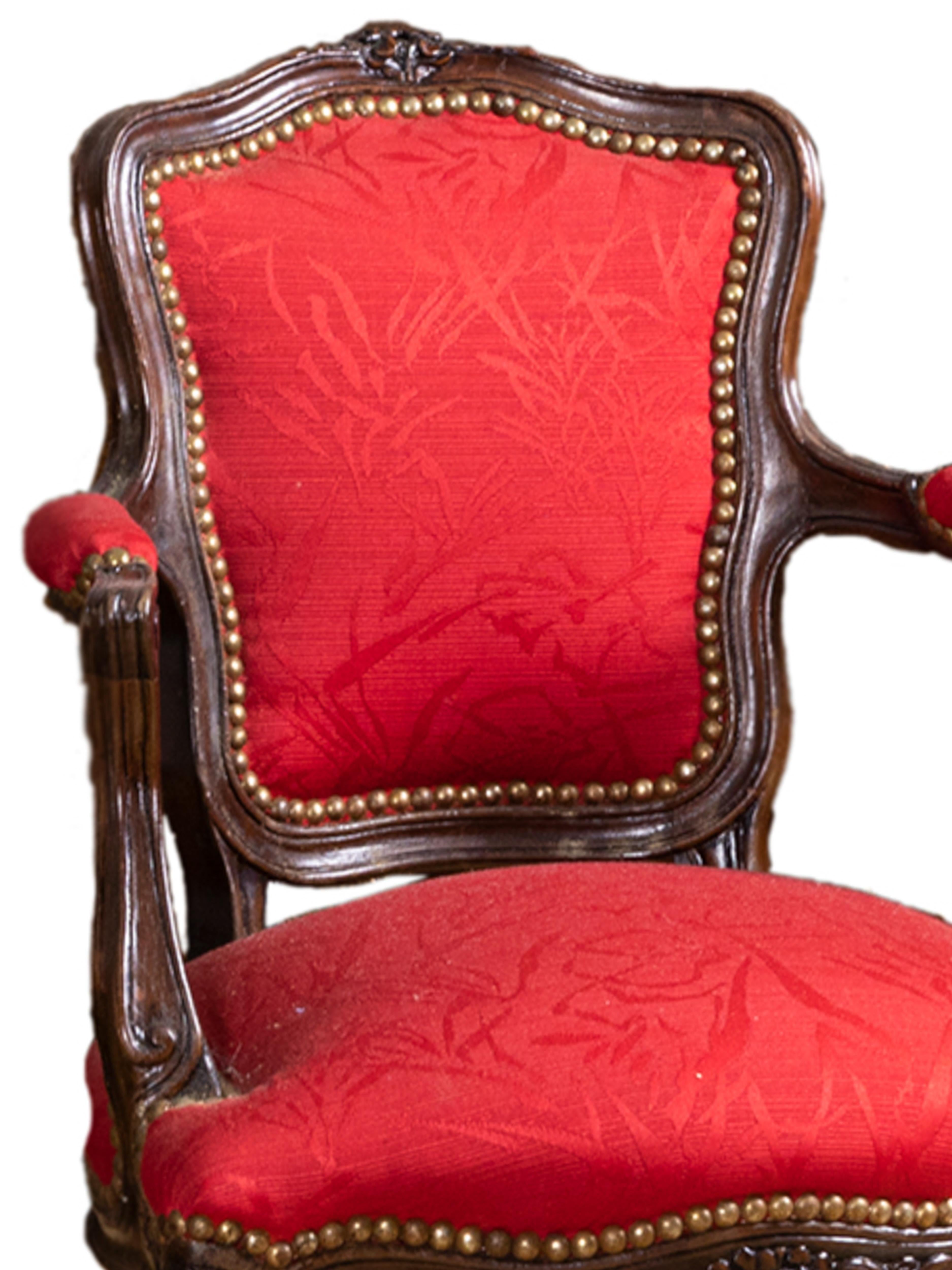 An extraordinary Louis XVI child armchair with carved wood, red silk damask and upholstery tacks.
A remarkable example of elegance for an unusual decor.. 
