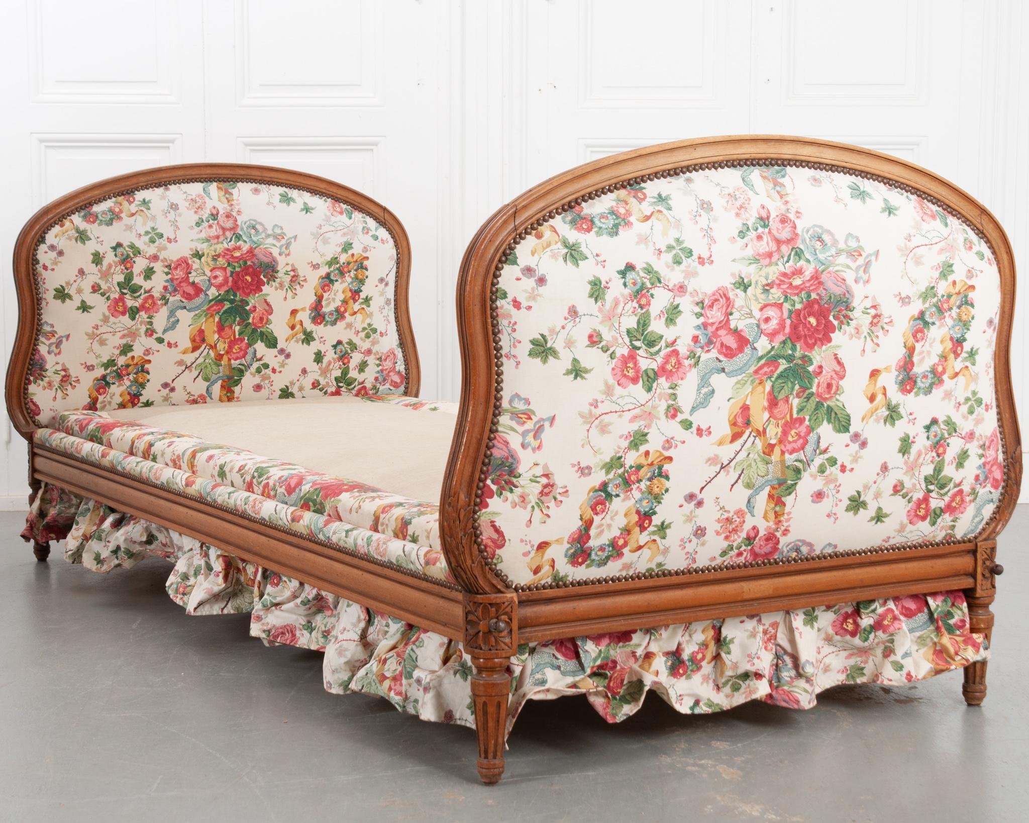 This fantastic day bed from the 1800’s was made of fruitwood in the style of Louis XVI! The shaped headboards are full of great details; a decorative nailhead trim securing the vintage floral fabric, carved rosettes at the corners, and fluted feet.