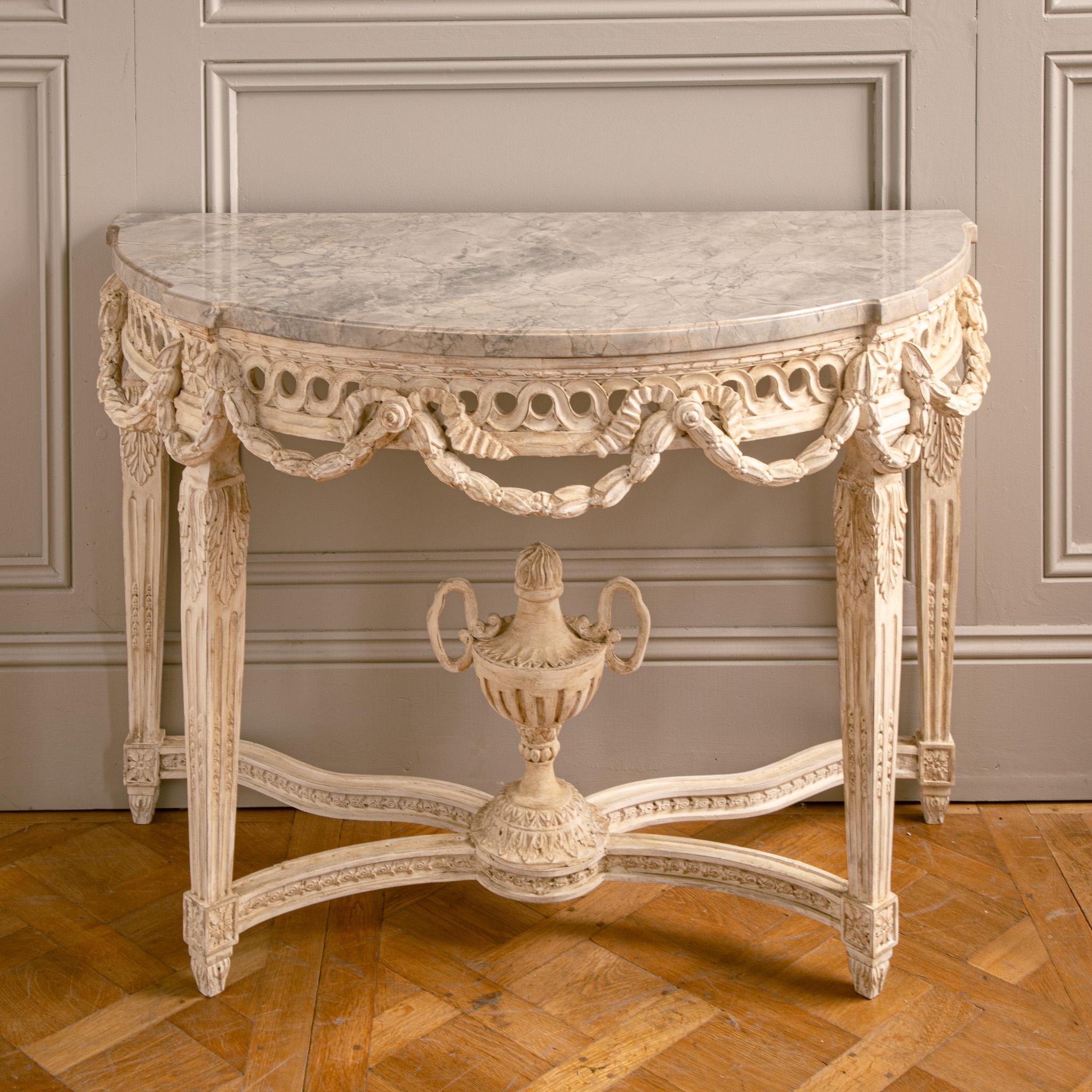 A finely handcrafted French Louis XVI style demi-lune console by La Maison London, known for their traditional craftsmanship and refined detailing.

This elegant piece features fluted legs with acanthus leaves and classic rosace medallions. The