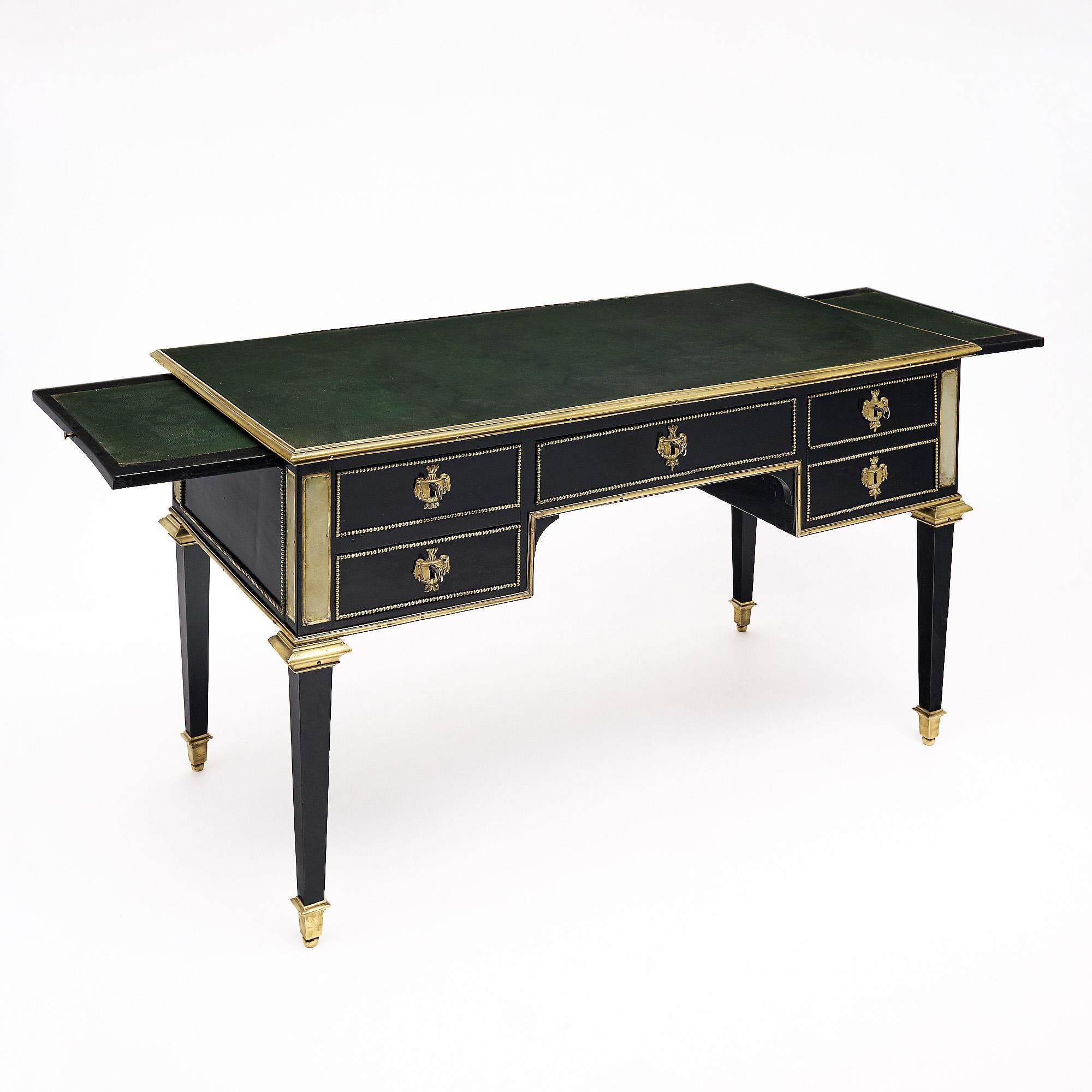 Scrivania francese in stile Luigi XVI in mogano, rifinita con una lucidatura francese di qualità museale. I contorni del tavolo da scrittura sono ricoperti da finiture in ottone dorato, mentre le finiture Pearl adornano i pannelli laterali e la