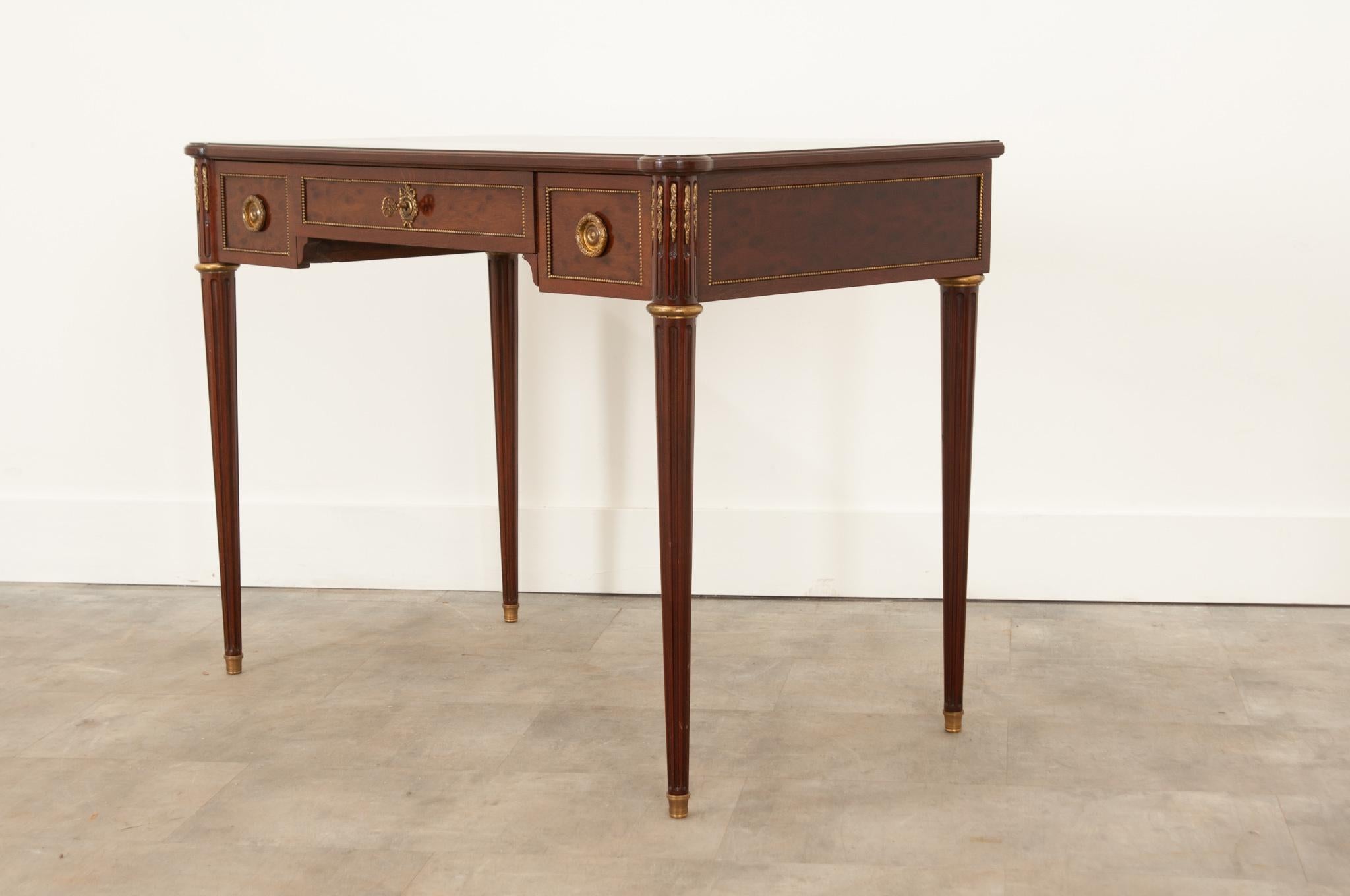 This striking bird’s-eye mahogany desk was crafted in France in the style of Louis XVI. The top is wonderfully smooth and displays the woodgrain beautifully. The apron houses three drawers, all with quality brass banding inset into the paneling. The