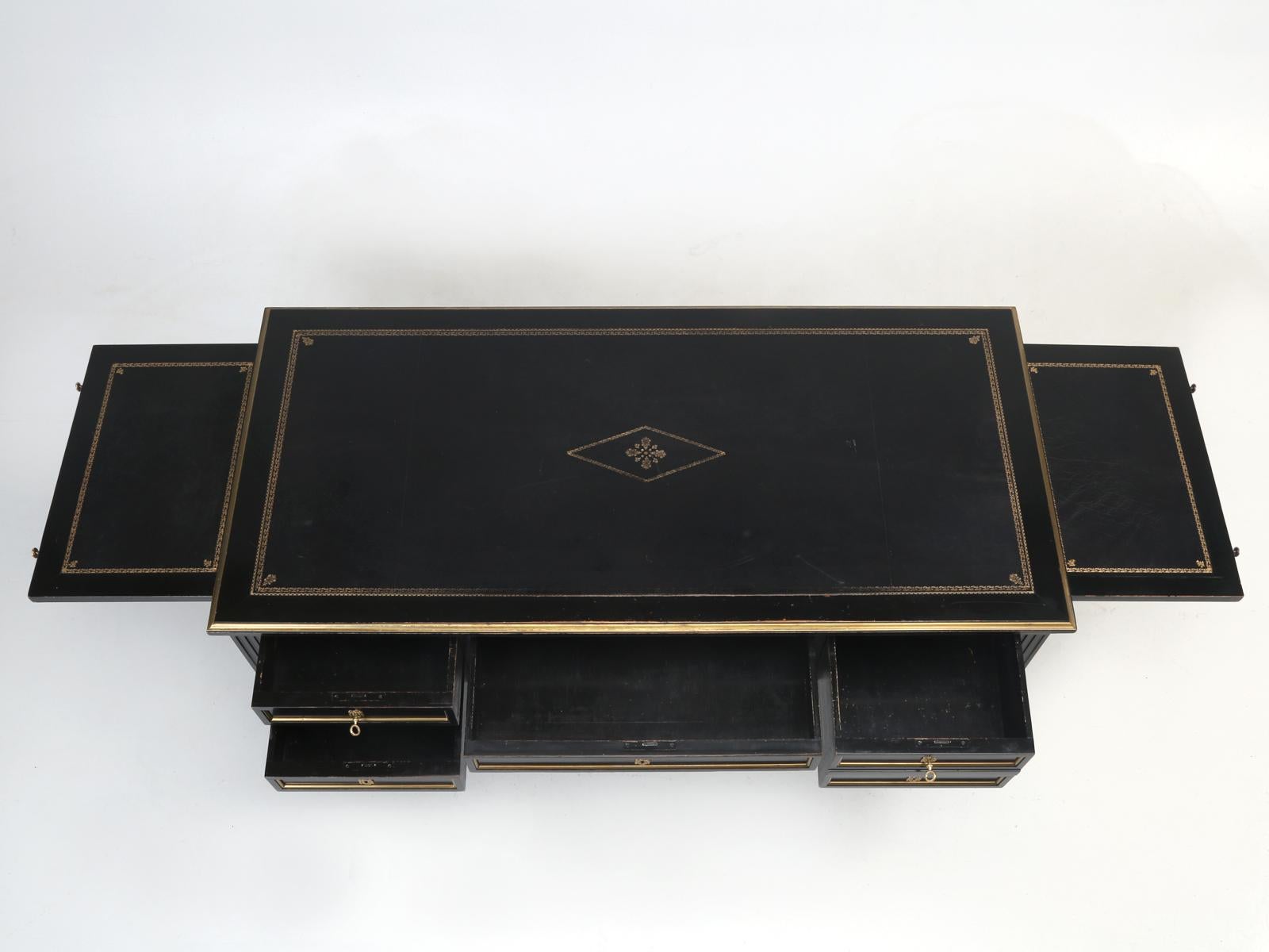 French Louis XVI style desk, in it’s original black lacquer finish, with a matching black leather top, that was tastefully adorned with gold trim. Difficult to determine, if this black lacquer French Louis XVI desk was made before the great war or