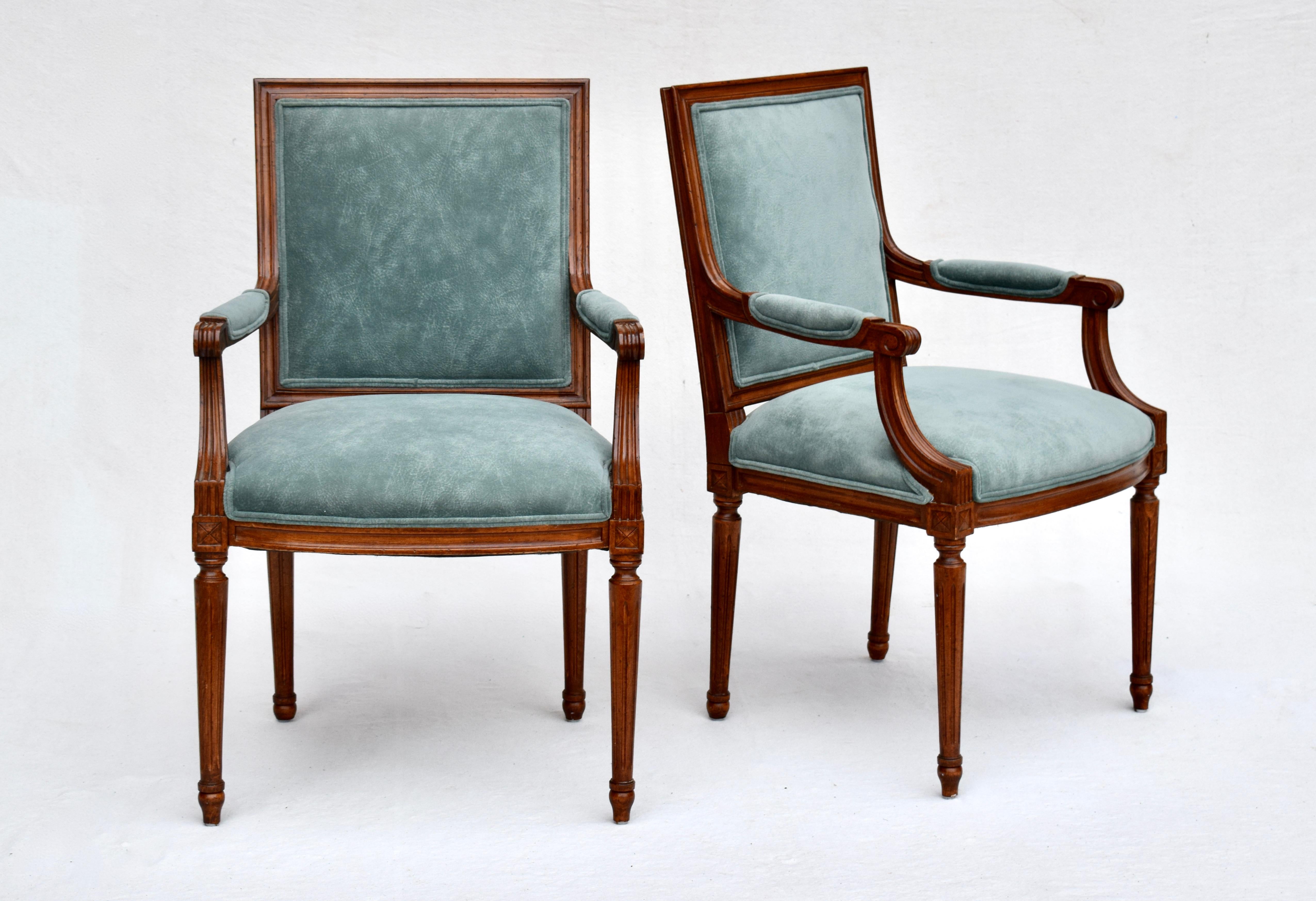 Exquisite set of eight mid 20th c. French Louis XVI solid walnut dining chairs. Two arm chairs & six side chairs are upholstered in a very convincing teal suede like faux leather; easy to clean & ready for use. The backs of the chairs feature woven
