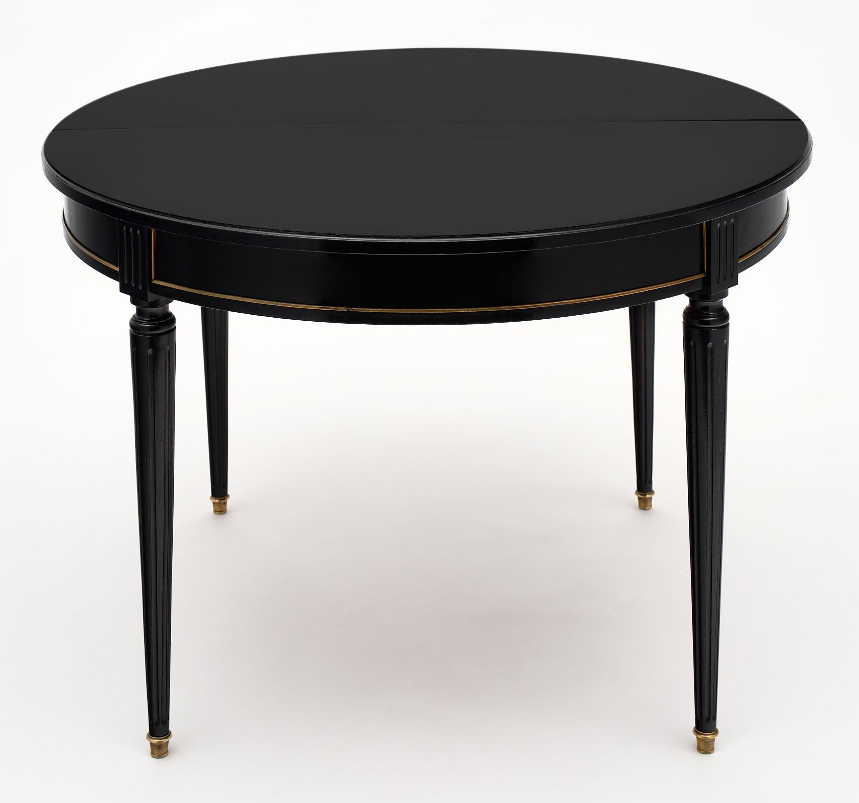 French Louis XVI style dining table made of solid mahogany and ebonized with a lustrous French polish finish. This table has one leaf which adds 15.375” to the total length.