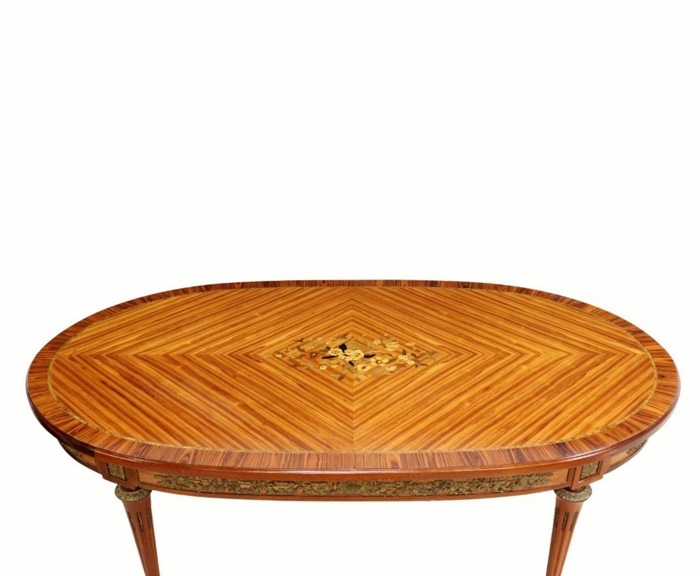 Add refined elegant warmth and Parisian sophistication to your dining room with this visually striking vintage, circa 1960s, Louis XVI style rosewood mahogany marquetry dining table in the manner of luxury designer Jean-Pierre Ehalt.

Exquisitely
