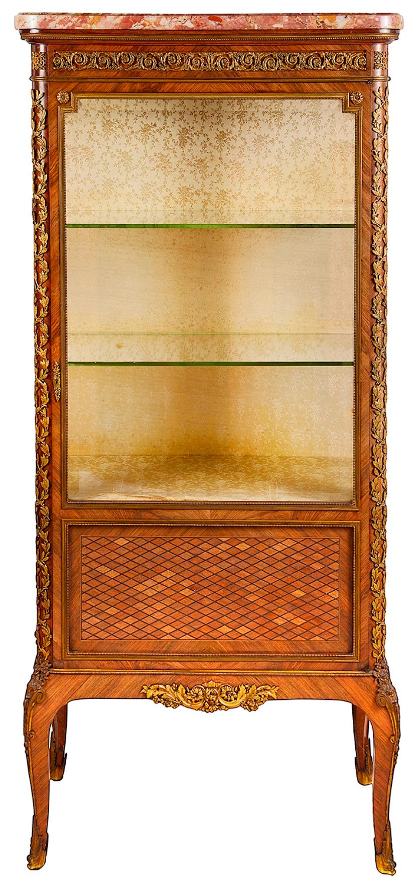 A fine quality late 19th century French Kingwood, marble topped Louis XVI style vitrine, having wonderfully fine gilded ormolu classical mounts, a single glazed door opening to reveal adjustable glass shelves within. Parquetry inlaid panels to the