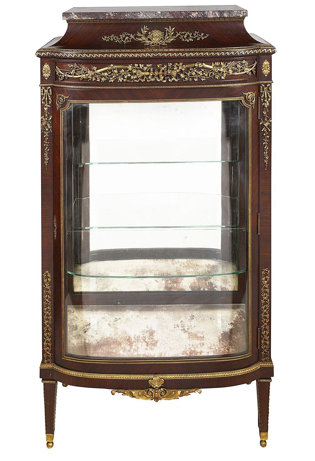 A very good quality French marble topped Louis XVI style bow fronted vitrine, having fine quality classical gilded ormolu mounts, a single glazed door opening to reveal glass shelves within. Riased on square tapering legs. In the manner of Francoise
