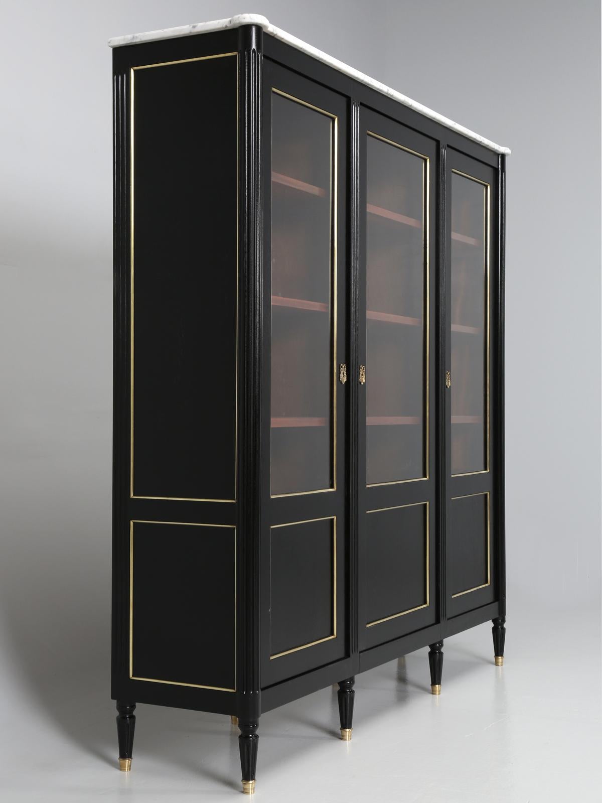 French Louis XVI style bookcase or bibliotheque in France. Our old plank finishing department, just completed hand-stripping of the mahogany bookcase and carefully applied an old fashion ebonized finish. The entire antique French Louis XVI style