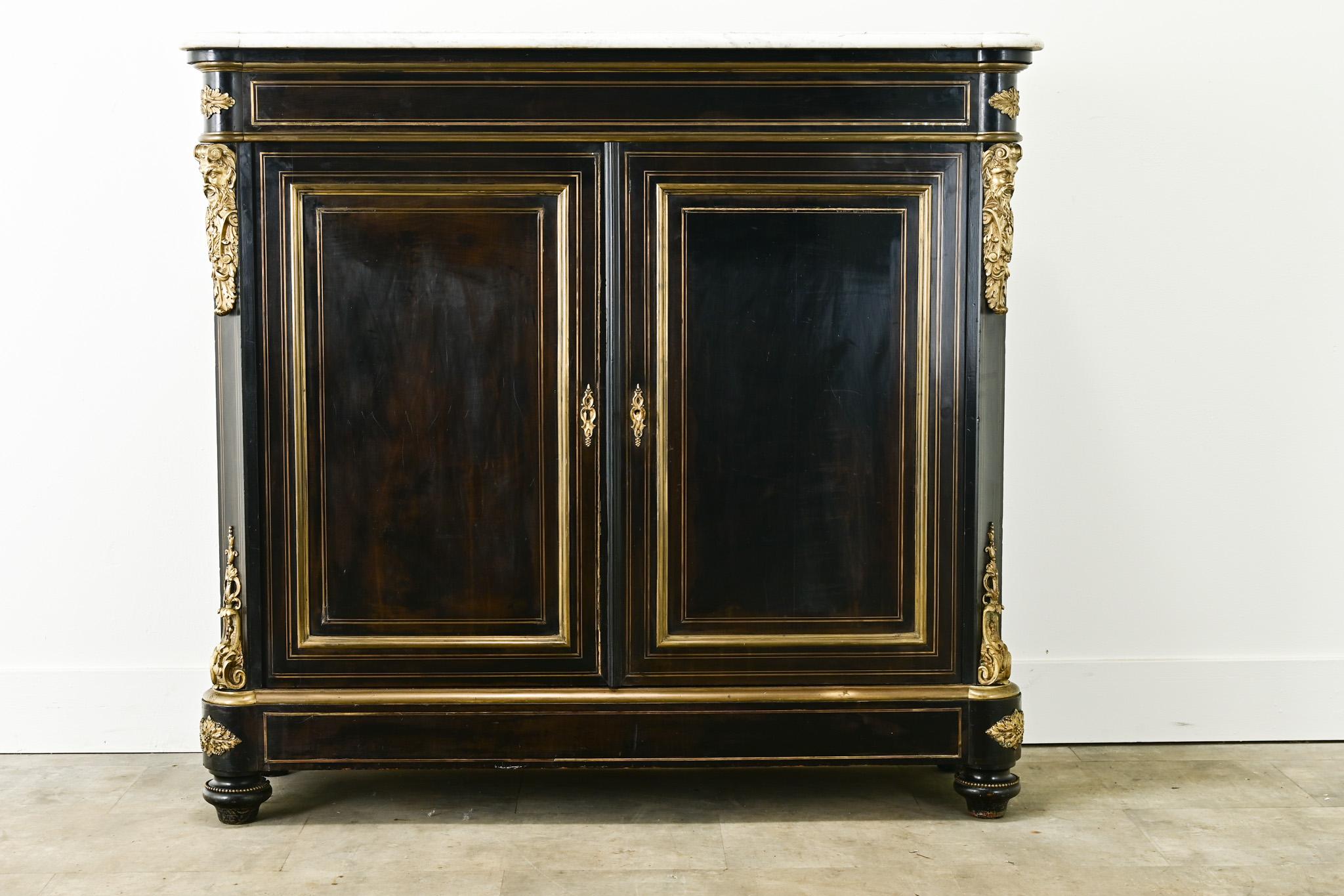 A tall French ebonized & ormolu buffet in the Louis XVI Style. This buffet has its original worn white marble top with rounded front corners that mimic the design of the base. The cabinet has a worn ebonized mahogany finish with impressive gilt
