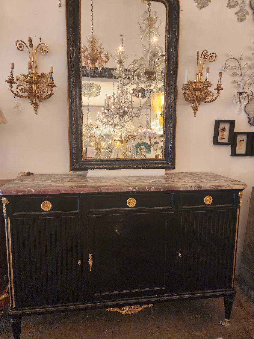 20th century French Louis XVI style ebonized sideboard. Has a marble top, three drawers in top of side cabinet doors. Gilt metal mounds, tapered legs, and capped feet. 