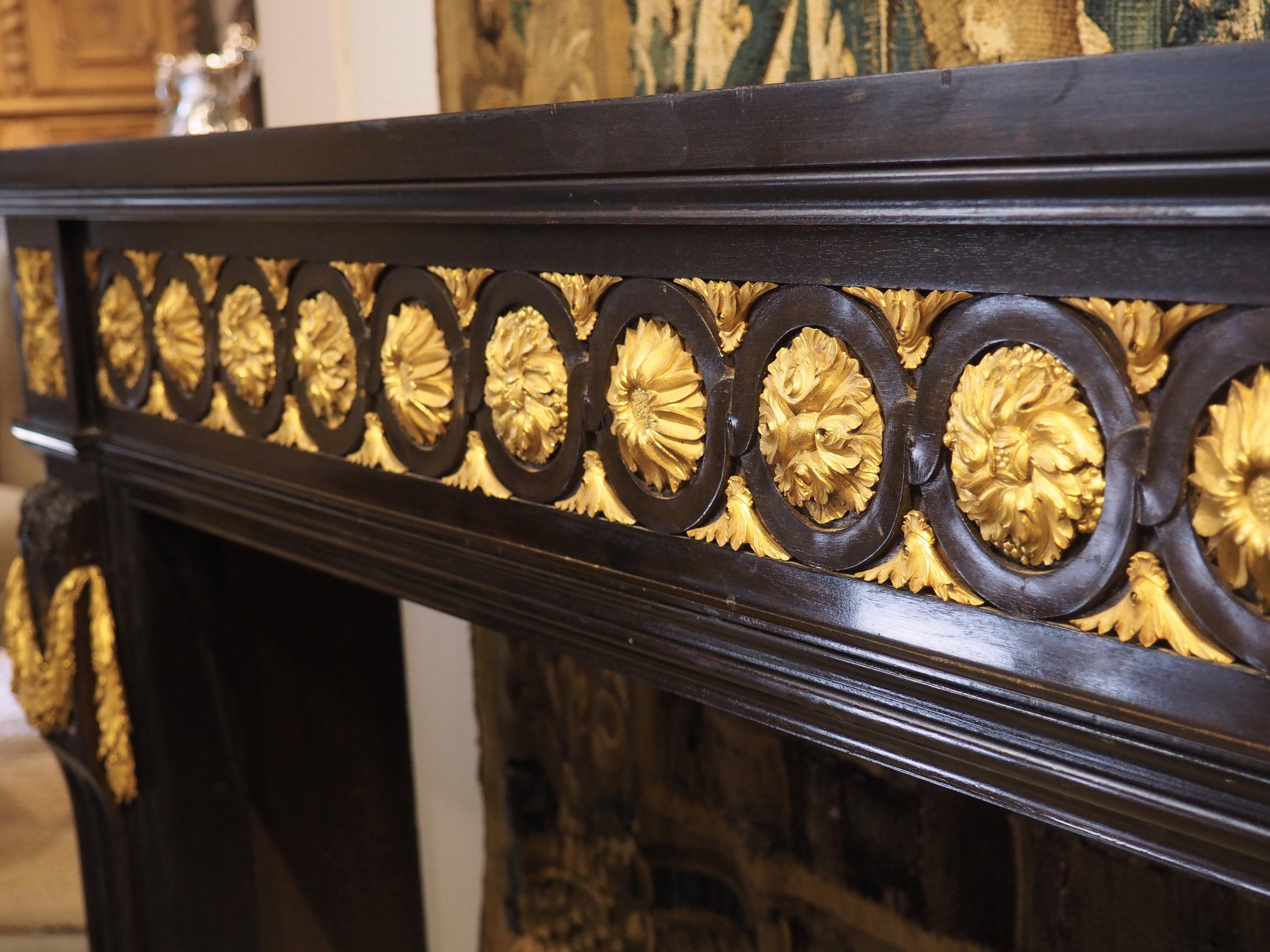 Hand-carved in the style of Louis XVI, this striking French wood mantel dates to the 1900s. Decorative motifs during the reign of Louis XVI were inspired by ancient civilizations (Rome, Greece, Egypt, etc.), thanks to the rediscoveries of Pompeii