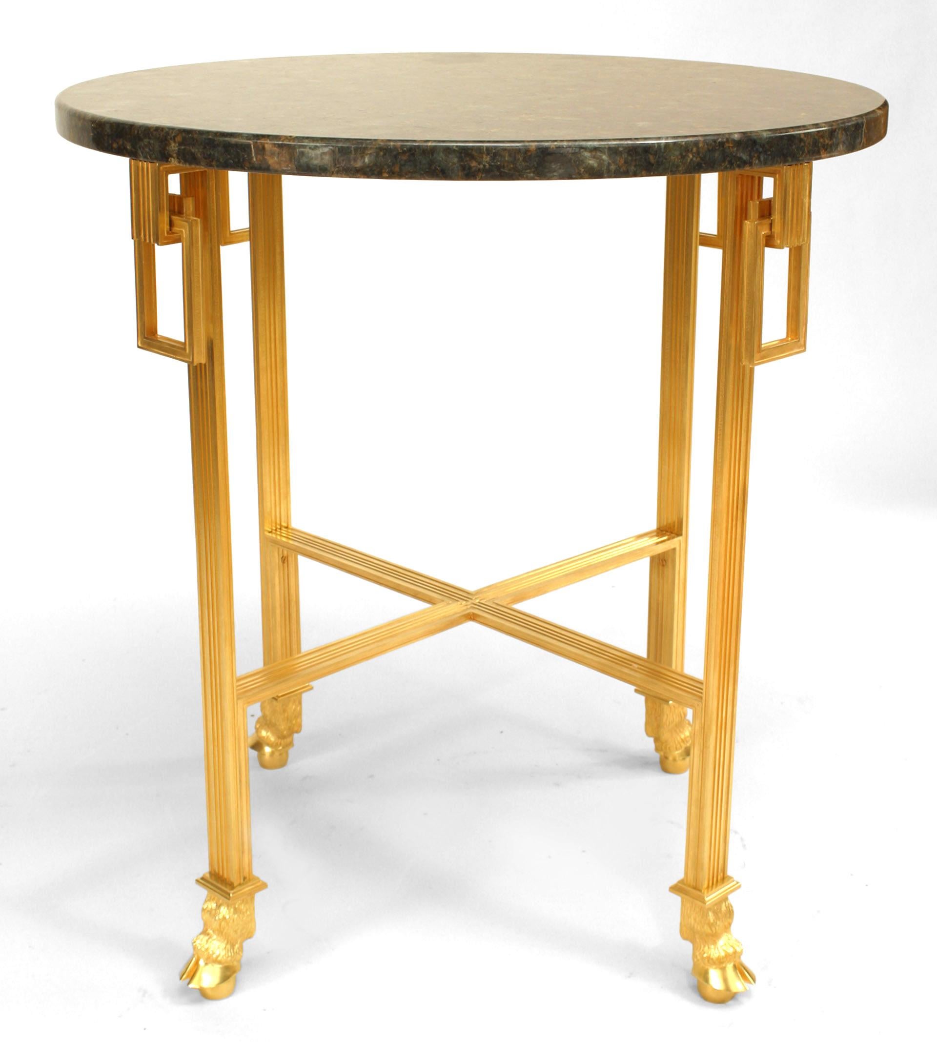 French Louis XVI style (20th century) bronze doré end table with fluted design legs holding rectangular rings and stretcher with hoof feet and round black marble top.