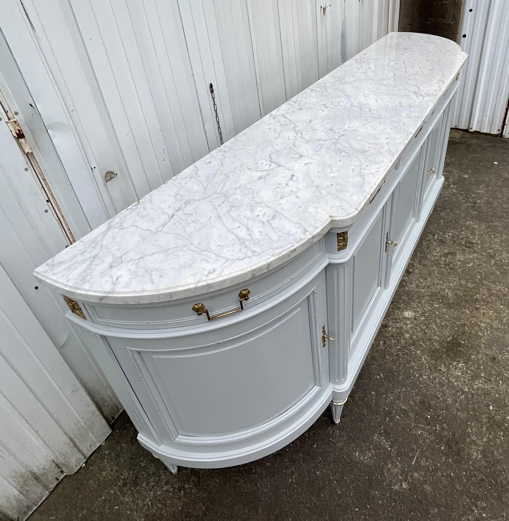 French Louis XVI style enfilade early 20th

This fruit wood sideboard opens with five doors opens with five doors (three straight doors on the front and two rounded doors on the sides) and five drawers arranged in the same way as the doors.

This