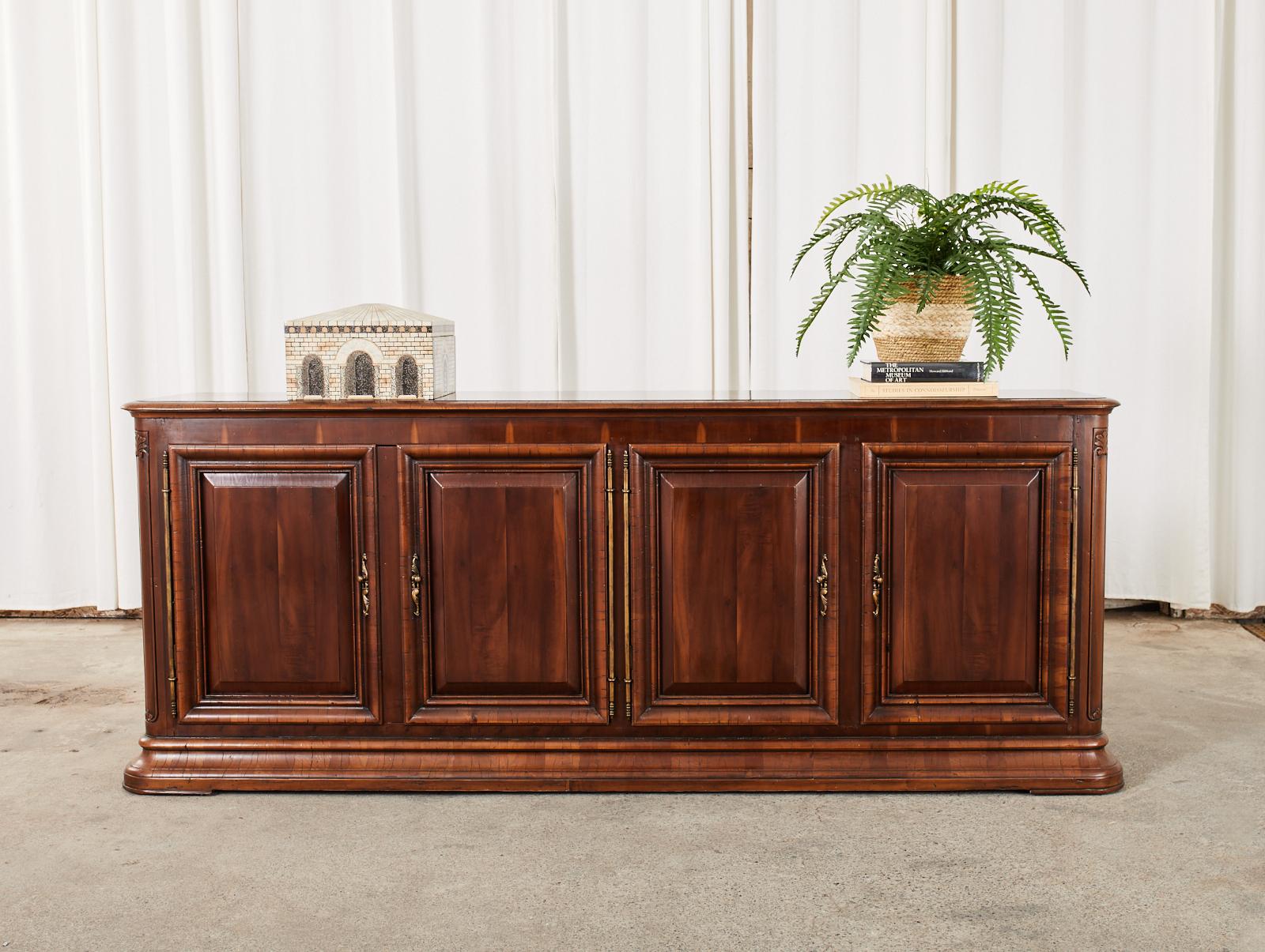 Grand enfilade sideboard buffet crafted from mahogany in the 19th century French Louis XVI taste circa 2006 by Alfonso Marina Mexico City, Mexico. The buffet features a mahogany case fronted by four doors having period correct style brass hinges,