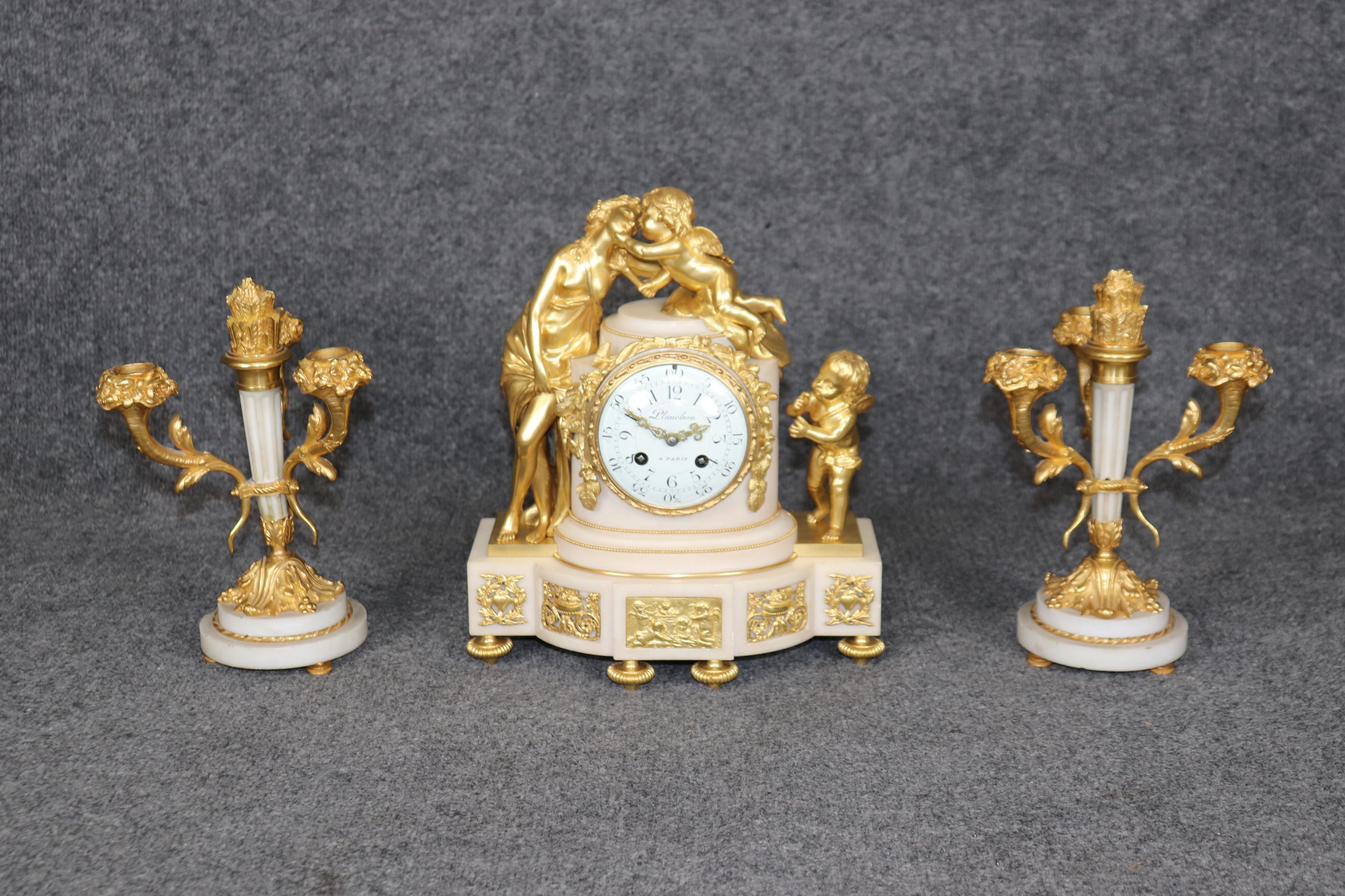 Dimensions- Clock:  H: 12 1/2in W: 11in D: 6in 
                       Candlesticks: H: 10 1/2in W: 7in D: 7in

This antique late 19th century Planchon Paris Louis XV style marble and ormolu mounted clock set is nothing but exceptional! This 3 piece