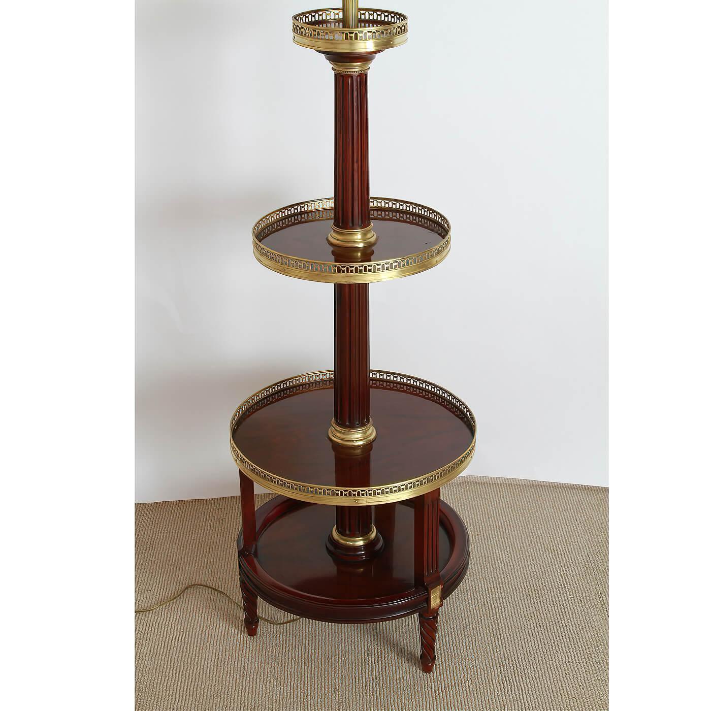 A French Louis XVI style mahogany four-tier floor lamp with circular tapering form, pierced bronze galleries, fluted supports and turned and fluted legs. France, ca 1940

Dimensions: 20