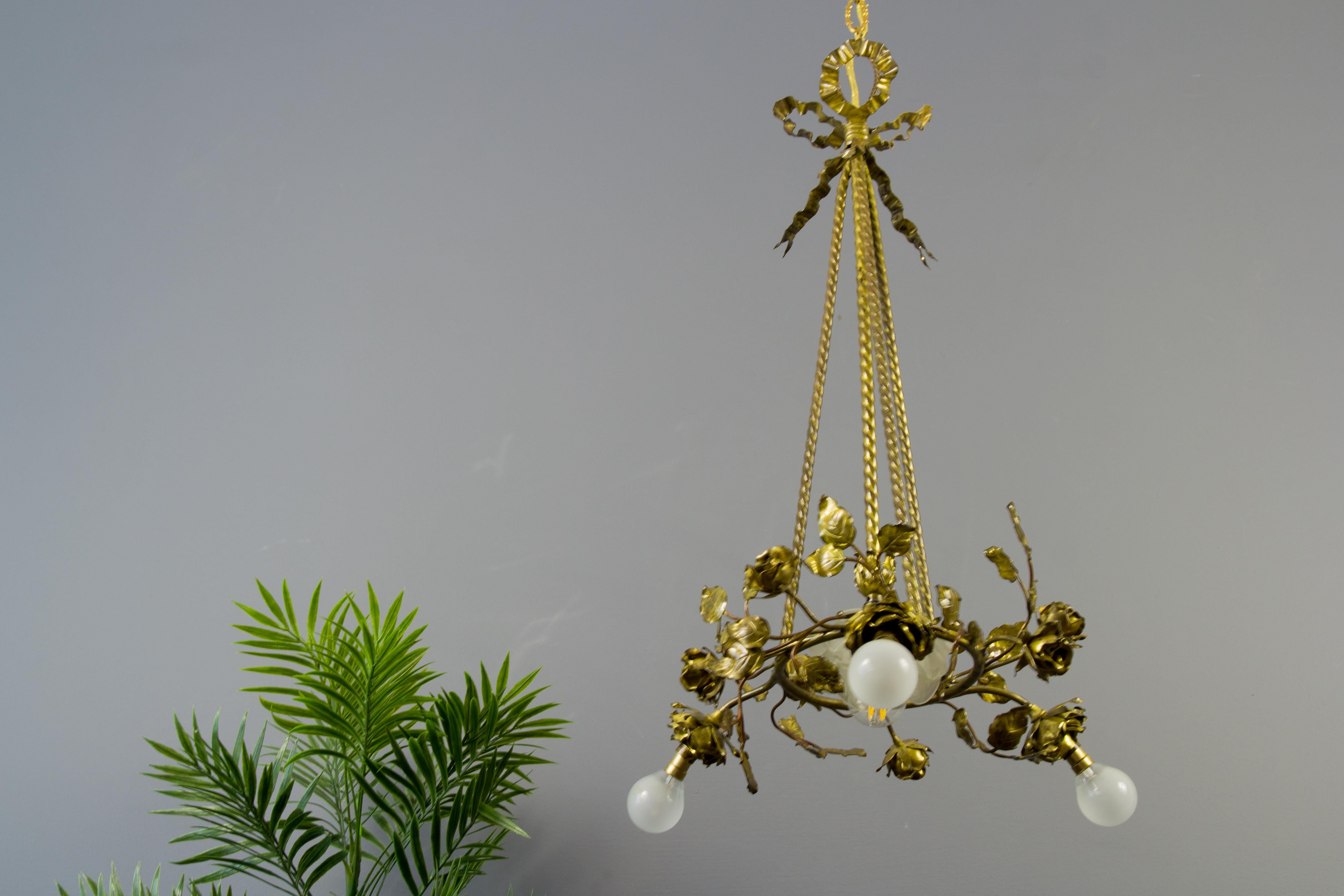 Beautiful French four-light chandelier shaped as swirling and flowering rose branches, suspended from four rope twisted rods with ribbon-tied canopy. In the center of chandelier is one flower shaped frosted glass shade. Three sockets (in bronze