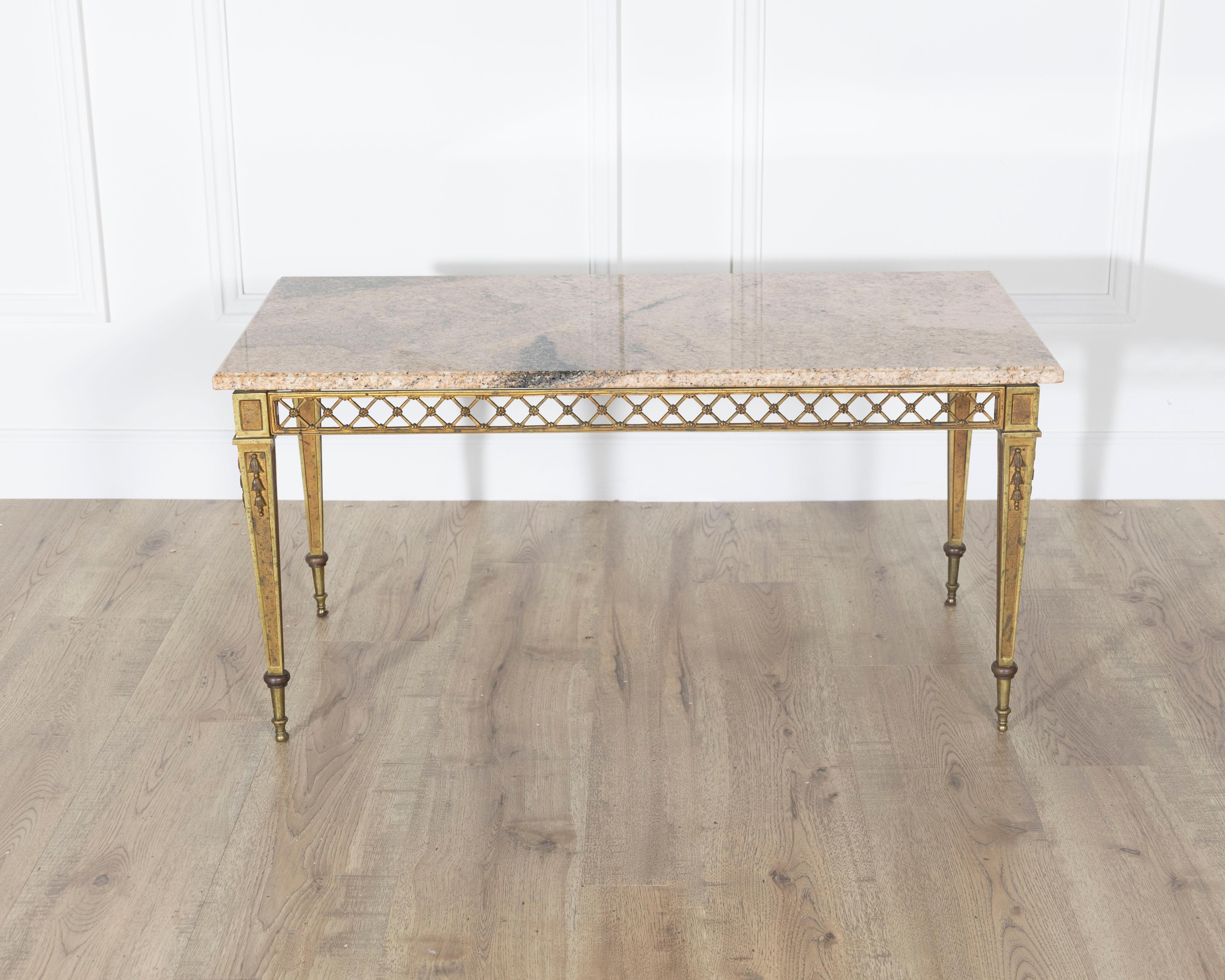 A rare and original Louis XVI style coffee table by the prestigious French design house Baguès, dating to circa 1940. This elegant piece features a finely cast and gilded bronze frame with an intricate lattice crosspiece motif running along the