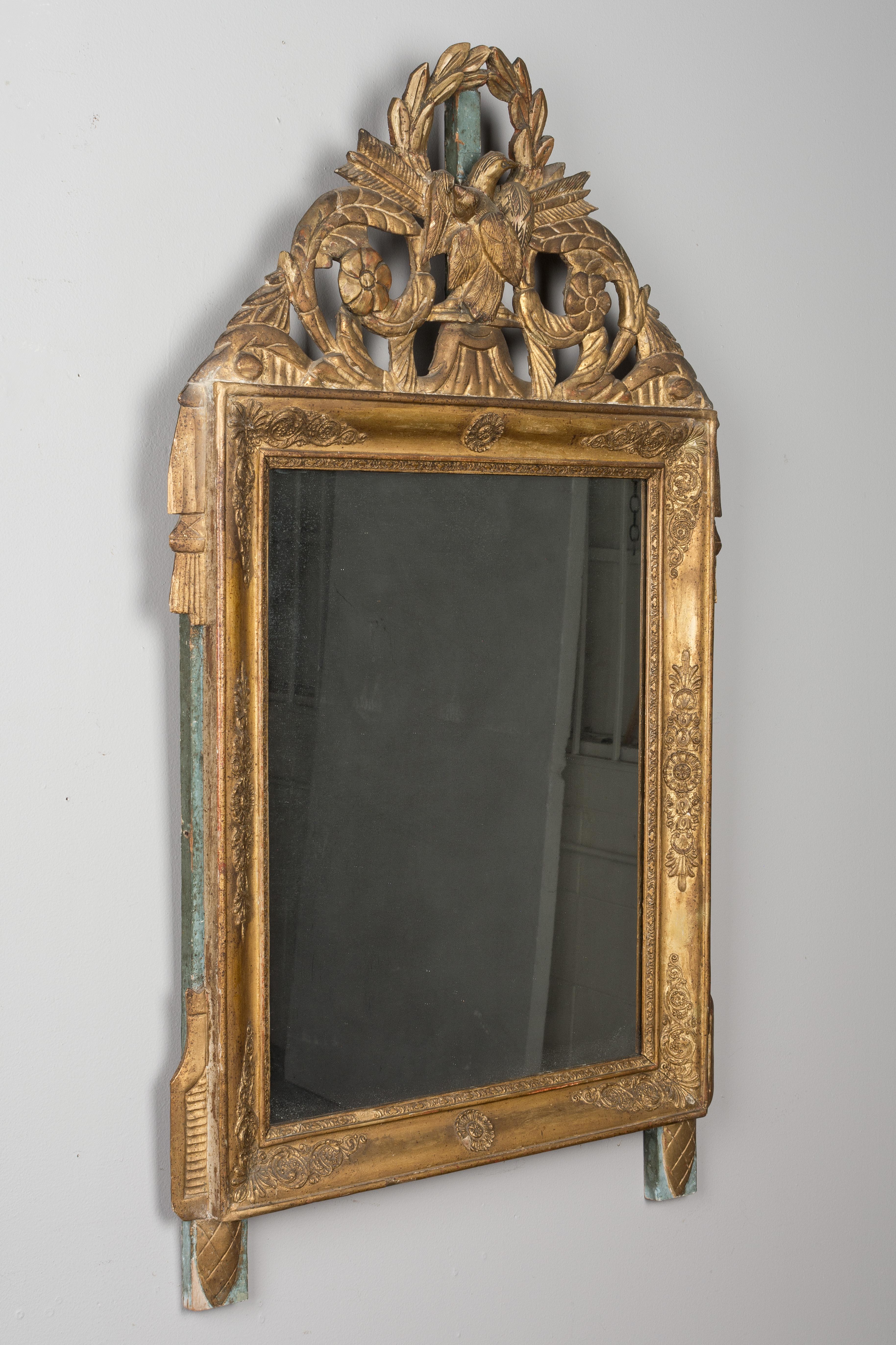 An early 19th century Louis XVI style French parcel-giltwood bridal mirror from Provence. Nice hand carved crest with a pair of lovebirds, scrolling leaves and laurel wreath. This is a Bridal mirror. All original with some restorations on the crest