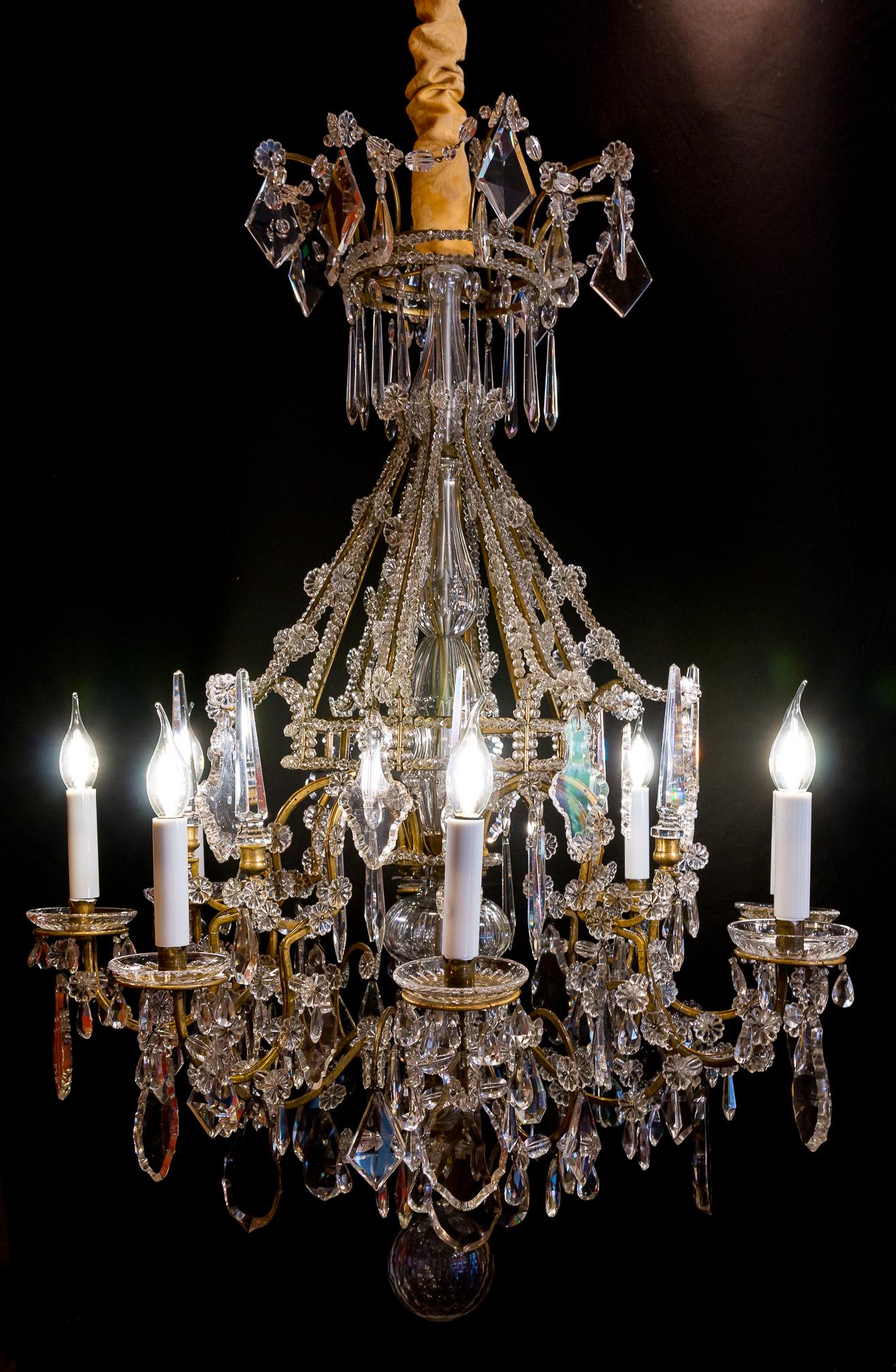 We are pleased to present you, an amazing gilt-bronze and hand cut-crystal, chandelier in the classic Louis XVI Marie-Antoinette style.
Our chandelier is composed of eight perimeter arm lights. 
Excellent quality white hand-cut crystal pieces,