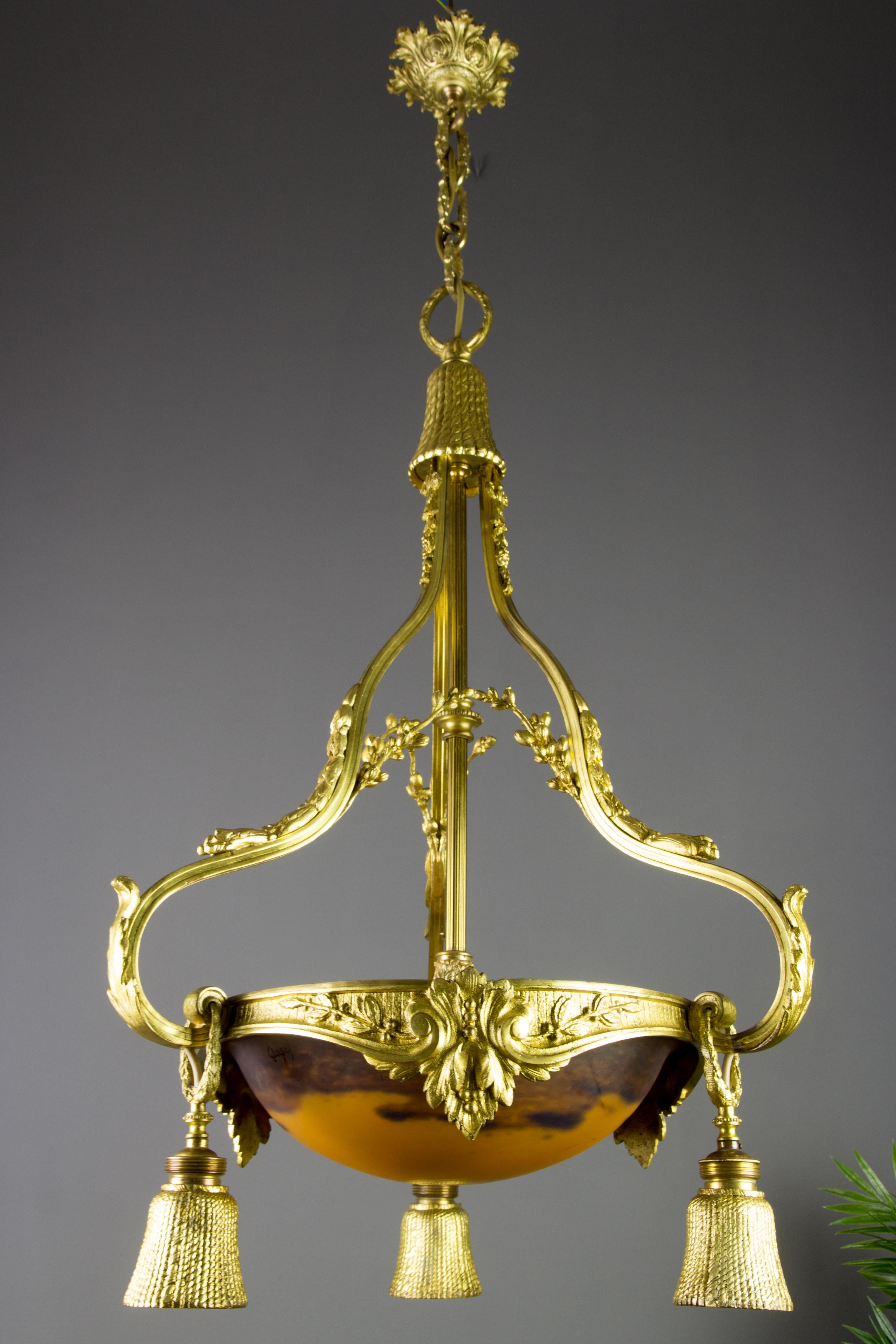 French Louis XVI style gilt bronze four-light chandelier with glass by Degué 
French Louis XVI style ornate gilt bronze four-light chandelier, decorated with acanthus leaves and branches. This antique chandelier features three bronze light socket