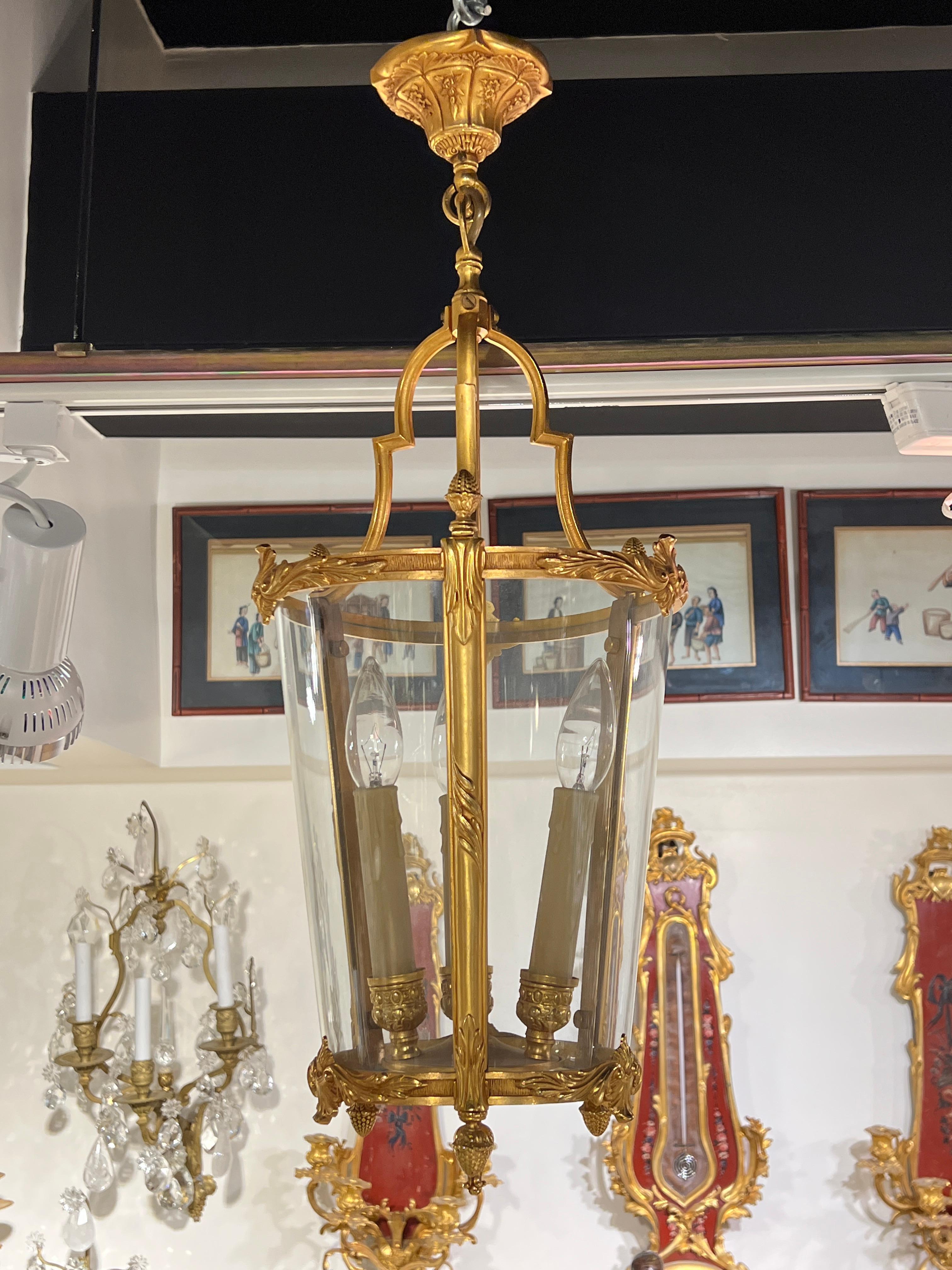 Gilt bronze lantern with three electrified sockets with faux wax candle covers distinguished by its three lobed glass panels.  With original ceiling plate and wiring, ready to hang and enjoy.  9 1/2 inches across and 25 inches tall as shown. 