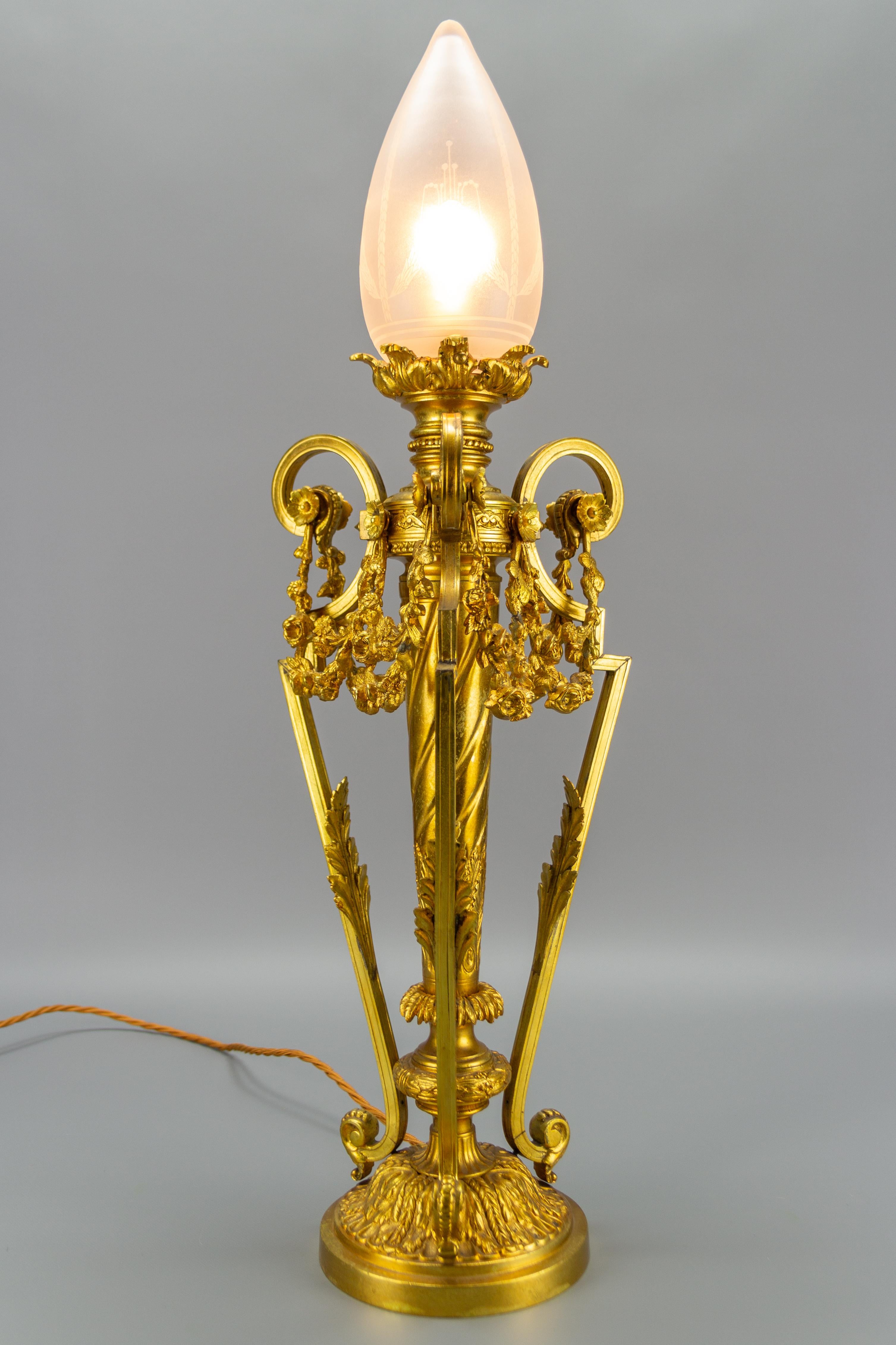 French Louis XVI style gilt bronze newel post lamp with frosted glass lampshade. Richly decorated with bronze decors in a form of acanthus leaves and floral garland drapes. The beautiful frosted glass oviform lampshade has delicate decorations.
One