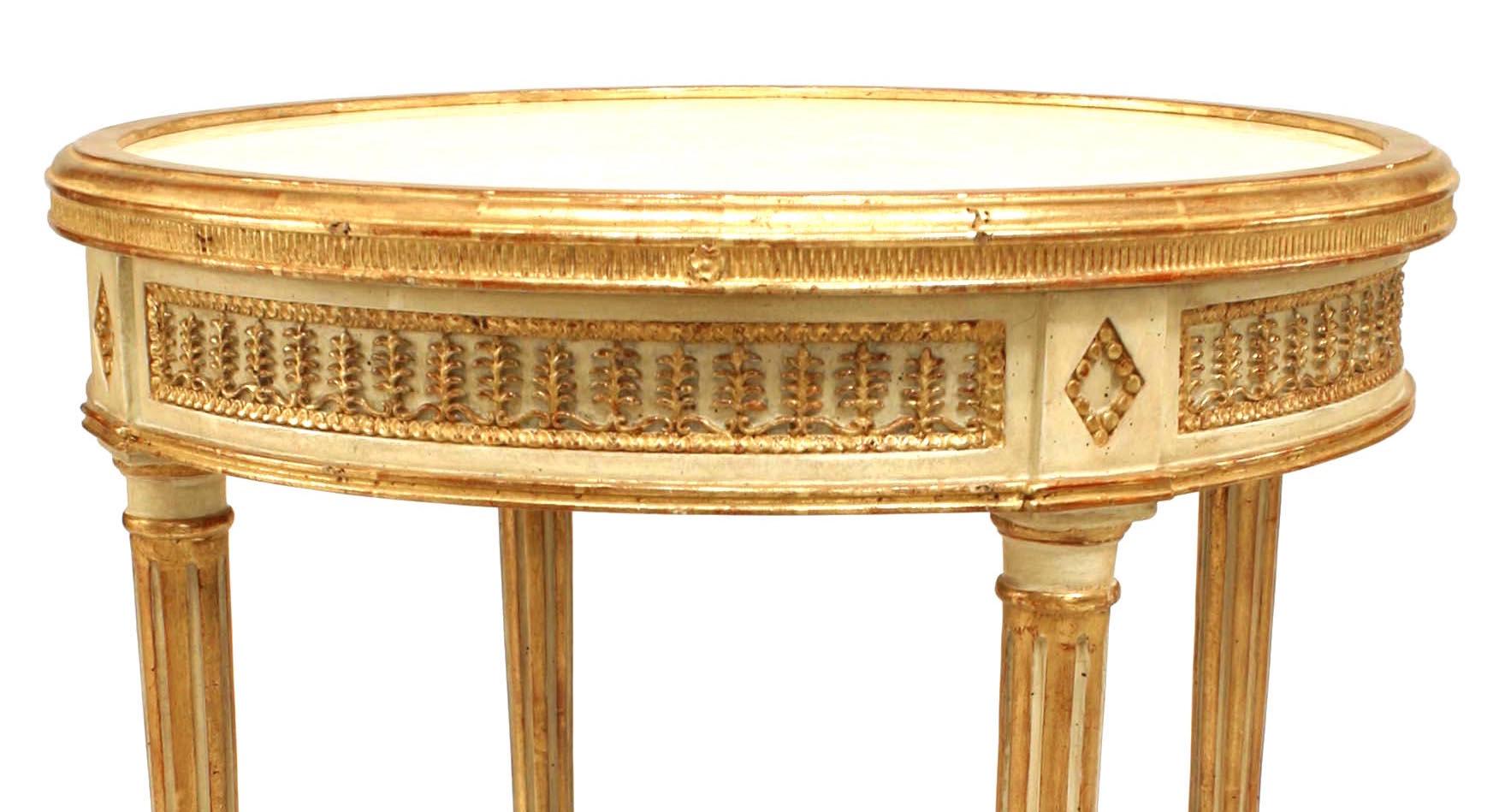 French Louis XVI-style (modern) white painted & gilt trim end table with a stretcher and carved acanthus leaf design apron with a round beige marble inset top.
