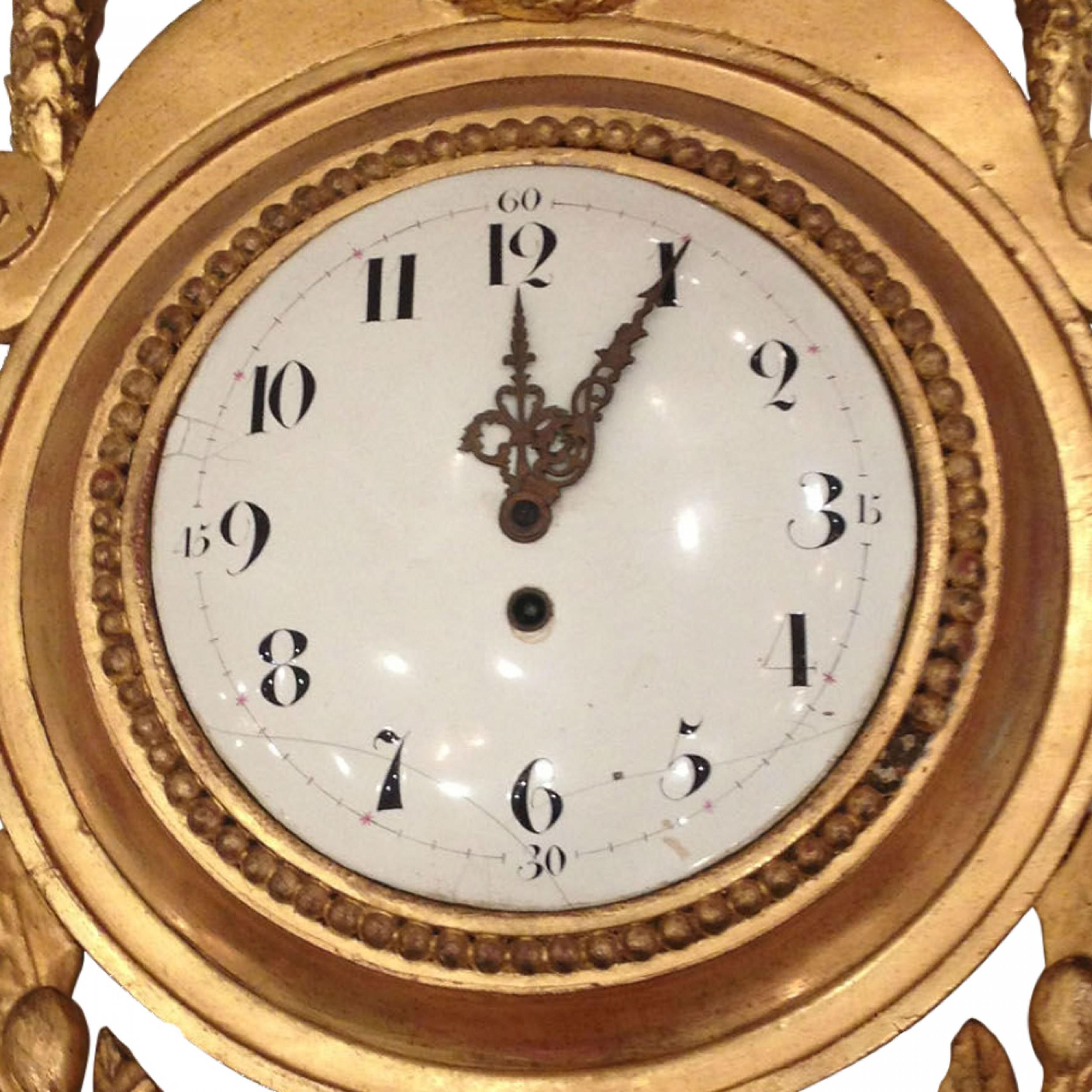 French Louis XVI-style (19th Century) gilt carved wall clock with a swag design pediment centering a lion and a wreath form bottom. (Not working)
