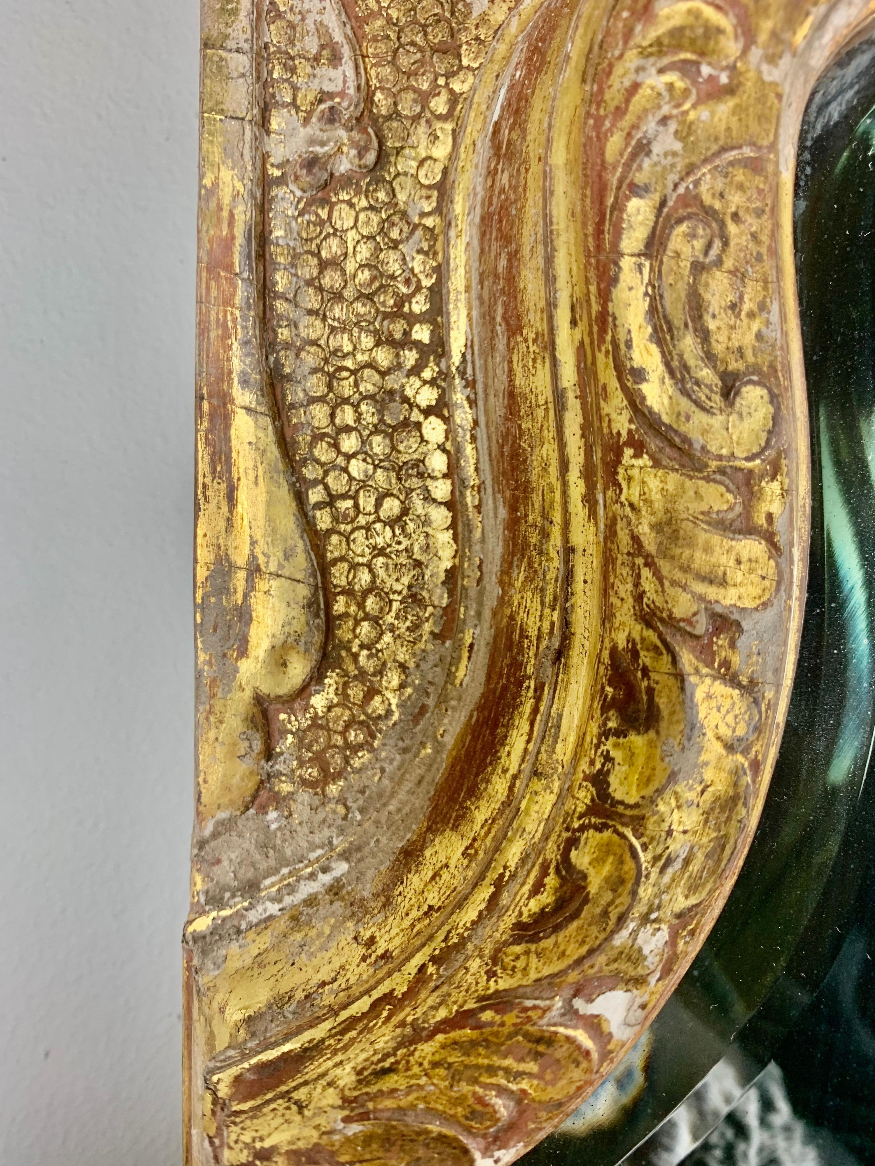 Französisch Louis XVI-Stil vergoldet Spiegel mit geschnitzten Details im gesamten. Es zeigt einen geflügelten Cherub, flankiert von Schriftrollen und Akanthusblättern. Ein Großteil des Blattgoldes ist abgenutzt, so dass das Holz darunter zum