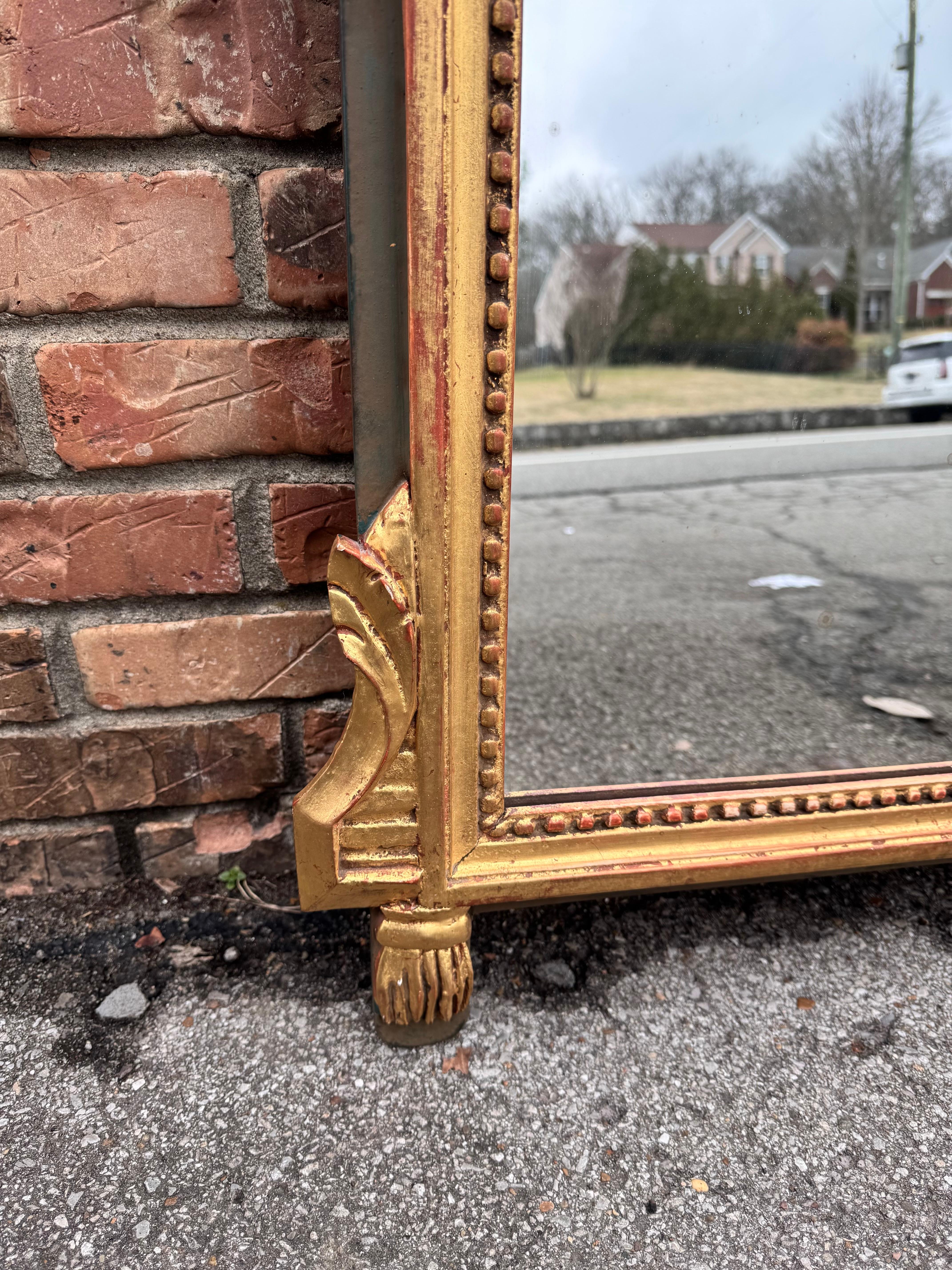 Antique Mirror francese in stile Luigi XVI con frontone decorato con nappe, foglie e motivi a cresta; la doratura ha una bella patina lucida.
Si adatta a qualsiasi spazio, sopra una consolle in un corridoio o come pezzo d'accento da solo. See One