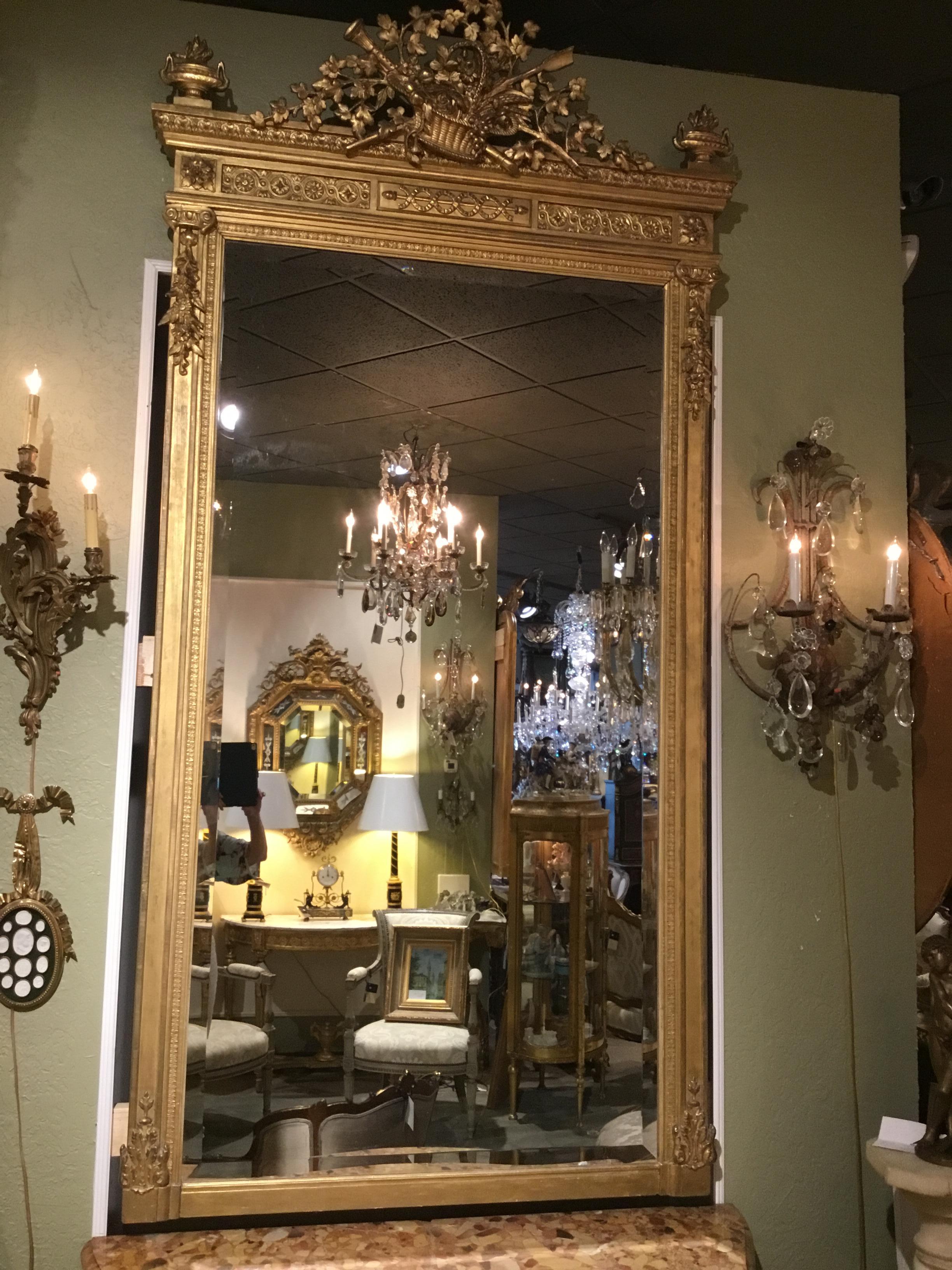 Hoch und elegant vergoldetes Holz 19. Jahrhundert Gerahmter Spiegel mit abgeschrägter Spiegelplatte.
Ein Korb mit Blattwerk und Blumenmuster mit einer Trompete und Pfeil geschnitzt sind
In der Mitte des Kammes dieses Stückes. Urnen mit einer