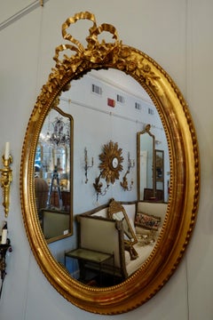 French Louis XVI Style Giltwood Mirror with Large Carved Bow Cartouche