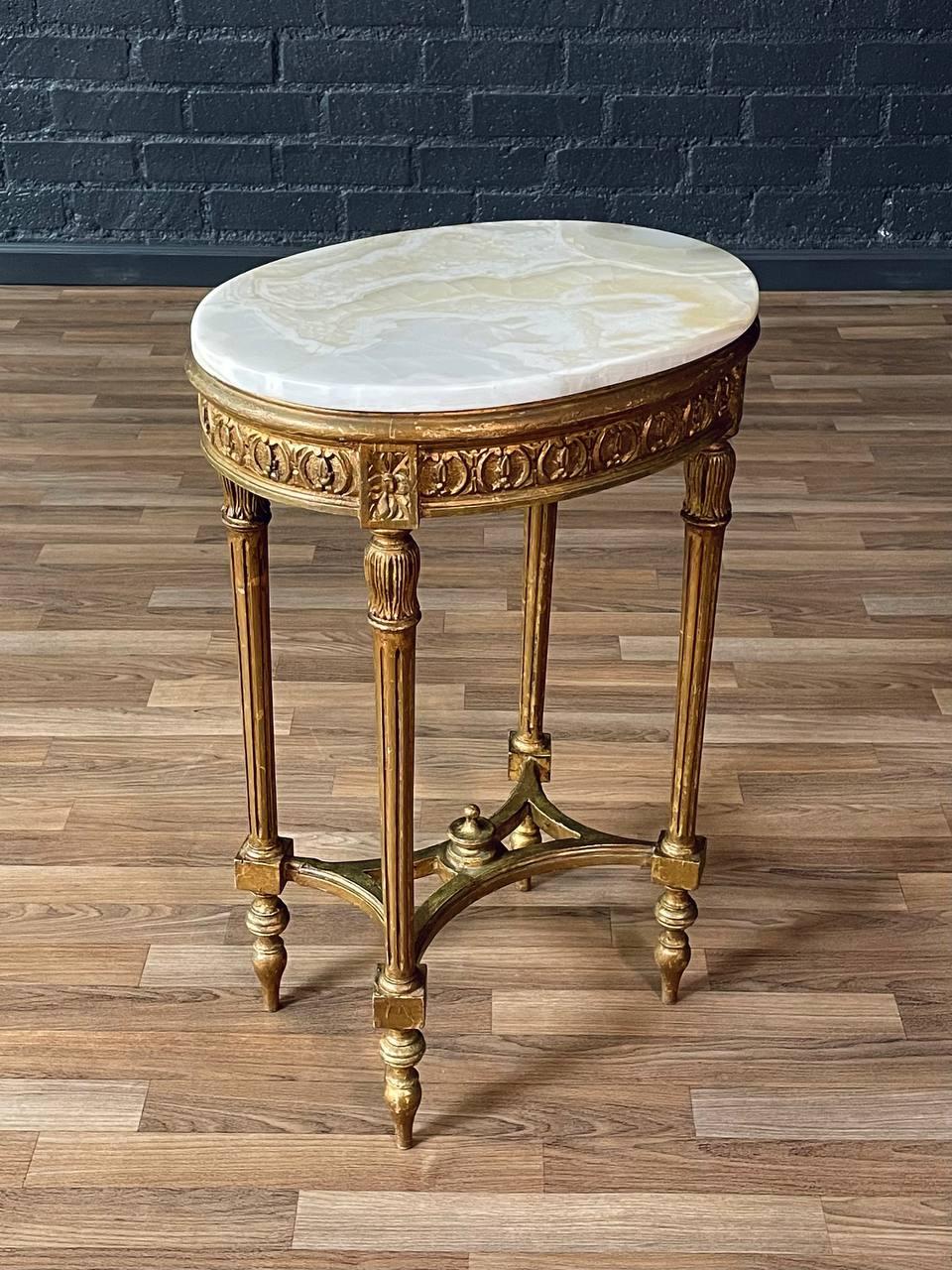 Zustand: Original Vintage By Zustand
MATERIALIEN: Gilt-Holz, Original Onyx-Stein 

Dieser elegante französische Beistelltisch im Louis-XVI-Stil zeichnet sich durch einen detailreichen Rahmen aus vergoldetem Holz aus, der seine ursprüngliche Patina
