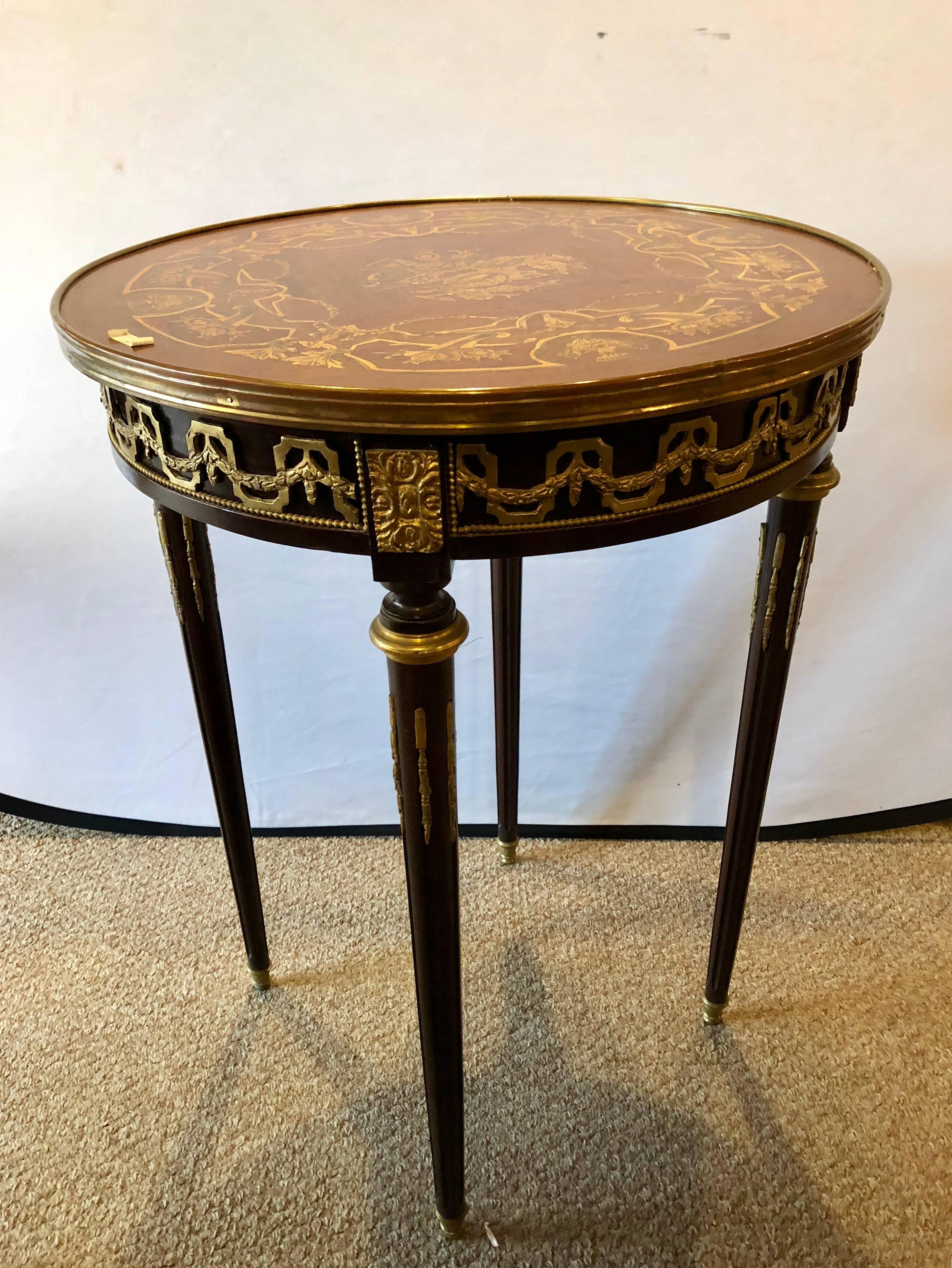 French Louis XVI style inlaid Bouilliote / lamp or end table. Having a wonderfully decorative inlaid top of satinwood design and heavy all over bronze mounts.