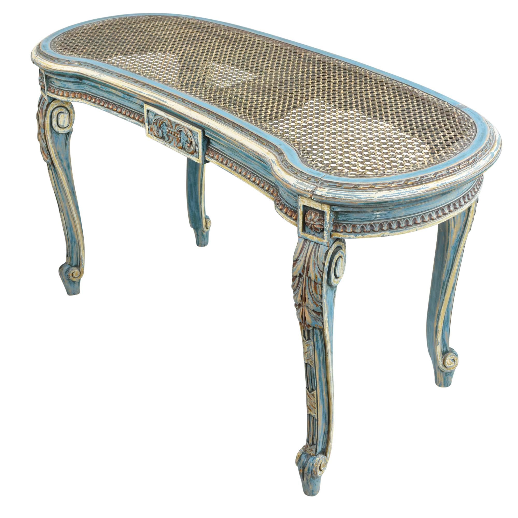 Beautifully carved French vanity bench in the Louis XV style features a kidney shaped solid wood frame. The frame is a lovely French blue with undertones of gold and soft brown where the finish has worn through. The frame has centre design on both