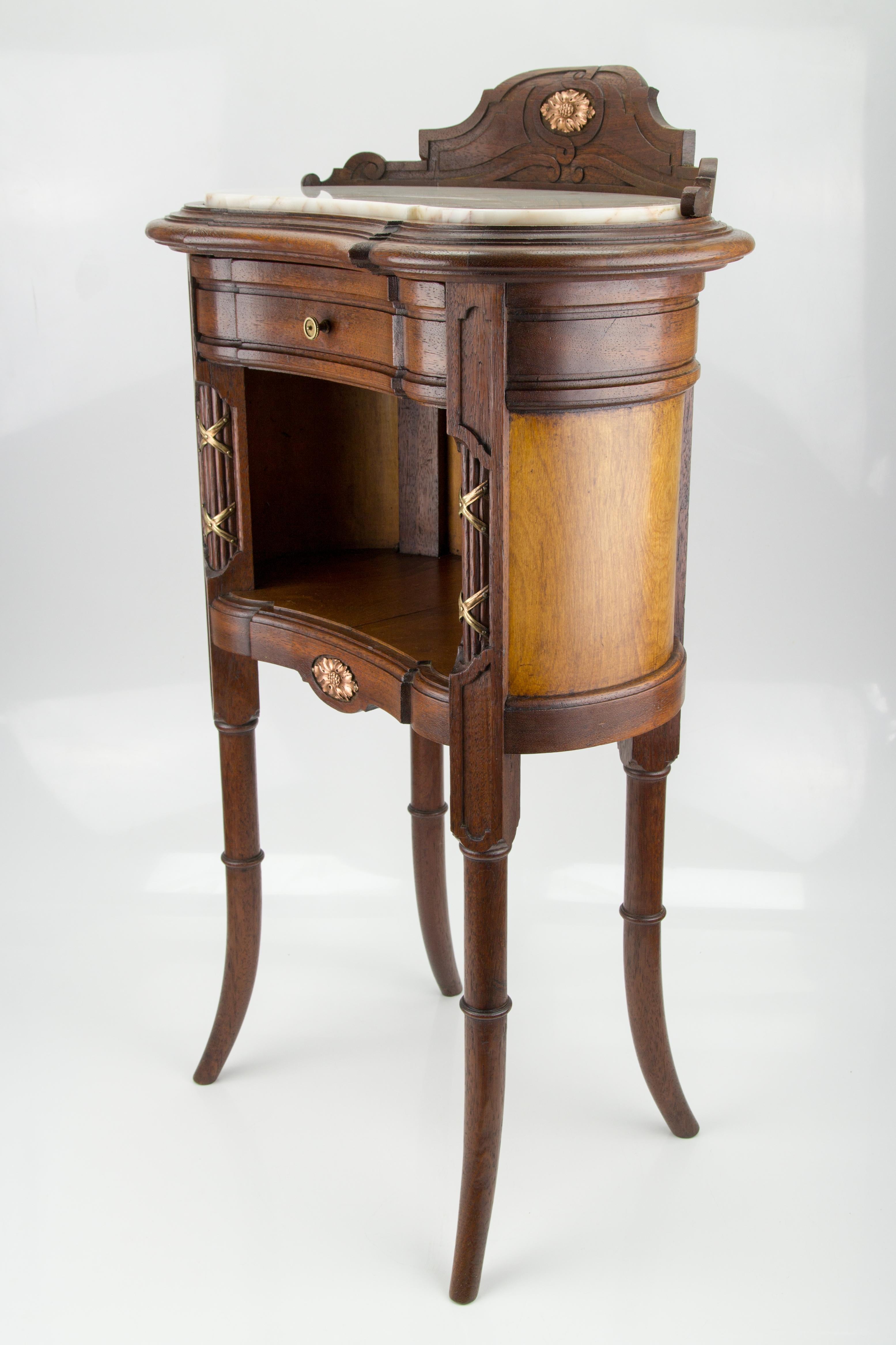 French Louis XVI-style kidney-shaped nightstand with marble top and brass mounts.
Adorable late 19th century Louis XVI style kidney-shaped nightstand or end table features a beige and ivory color marble top, one drawer, and beautiful brass mounts, a