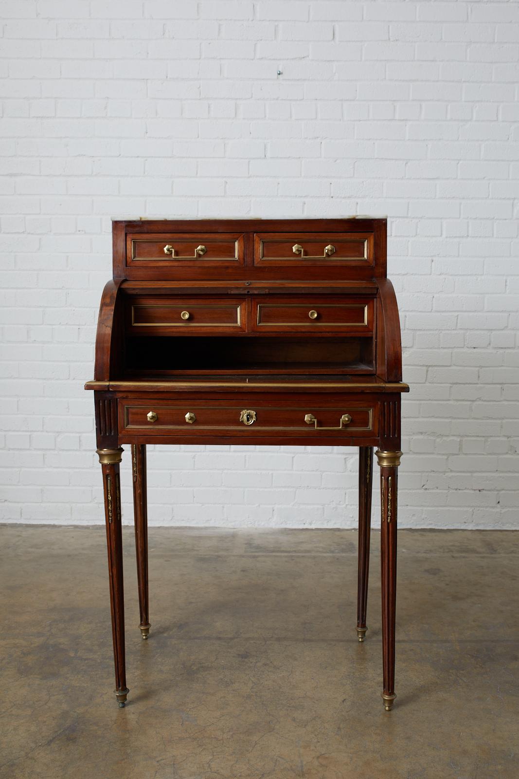Elegant French ladies bureau, writing table, or desk made in the grand Louis XVI taste. Features a roll top cylinder style case topped with a piece of Carrara marble. Made in the style of a 