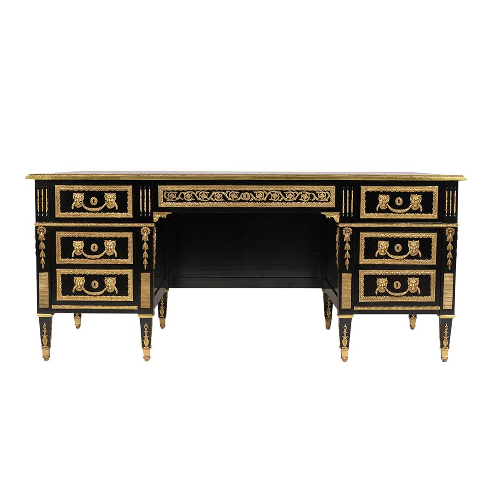 This French Louis XVI style desk has been professionally restored, is made out of mahogany wood, and features a newly black lacquered finish. The desk comes with an elegant black leather top with embossed gilt trim details framed by a flat brass