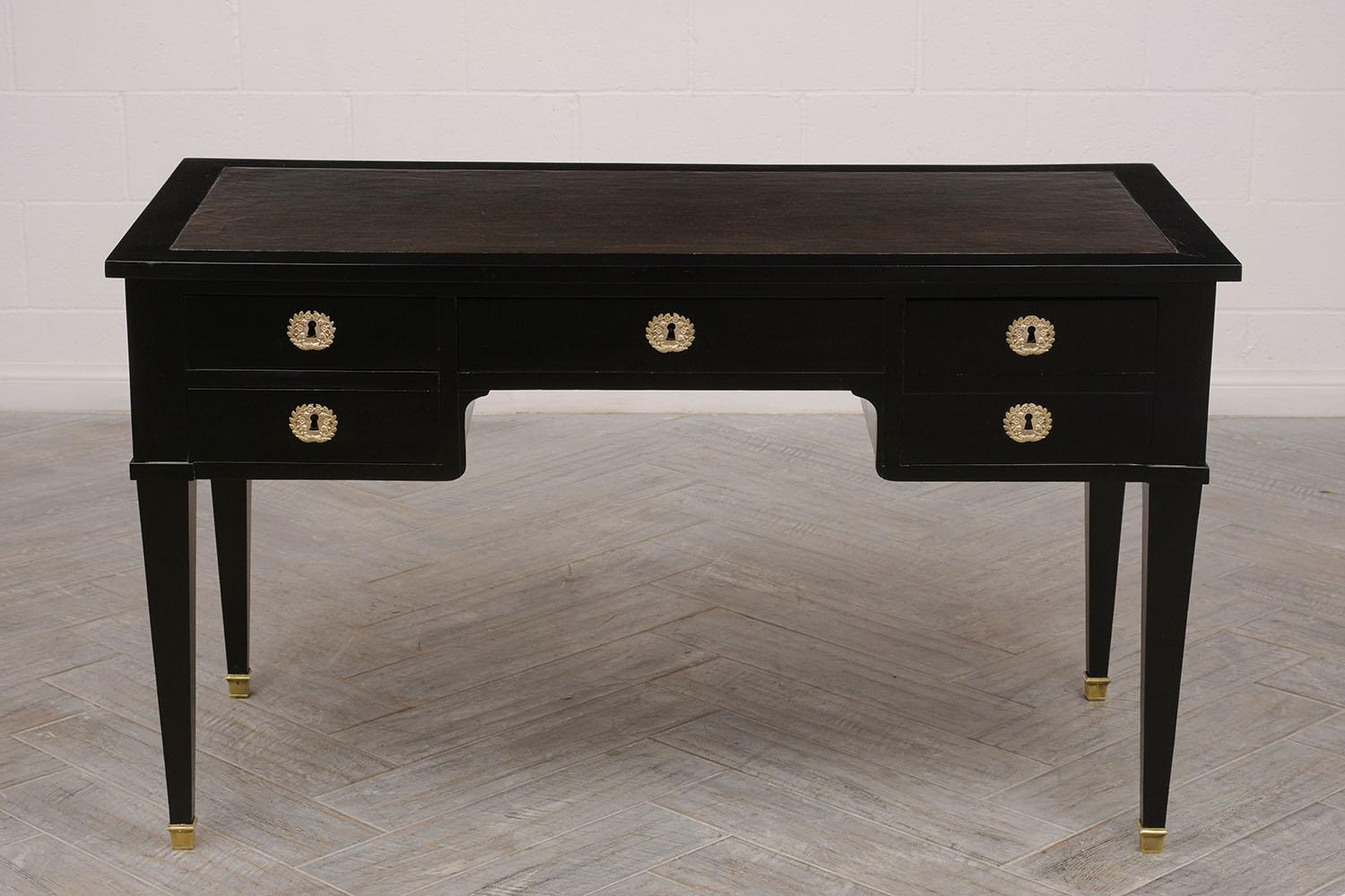 Elegant 1900s Louis XVI-style desk. Solid mahogany wood, newly refinished in a black lacquered color. Original dark brown leather top. Desk features two leaves with leather tops, one on each side. One large center drawer with bronze design key