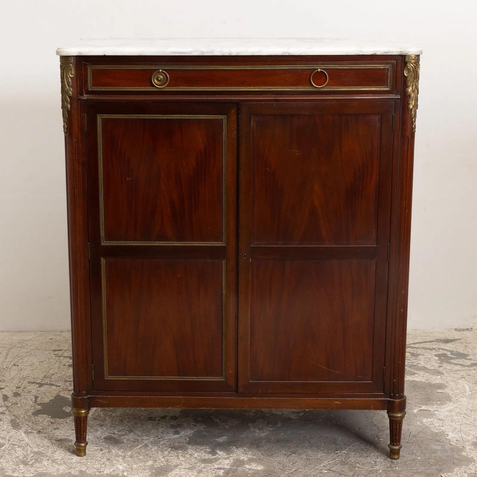 Gorgeous French Louis XVI marble top 2-door cabinet. Beautiful original carvings and bronze ormolu accents. The marble is original white in color. Perfect storage for just about anything. Just add the shelves you need. Add some French style to your