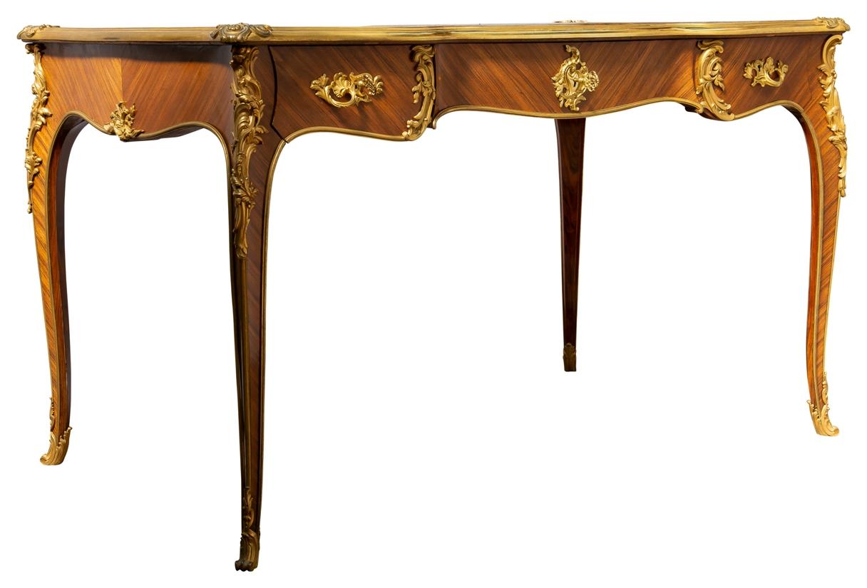 .A fine quality late 19th century Mahogany Louis XVI style bureau plat, having wonderful scrolling foliate gilded rococo style ormolu mounts to the elegant cabriole legs and drawer fronts. Three Oak lined frieze drawers, dummy drawers to the reverse