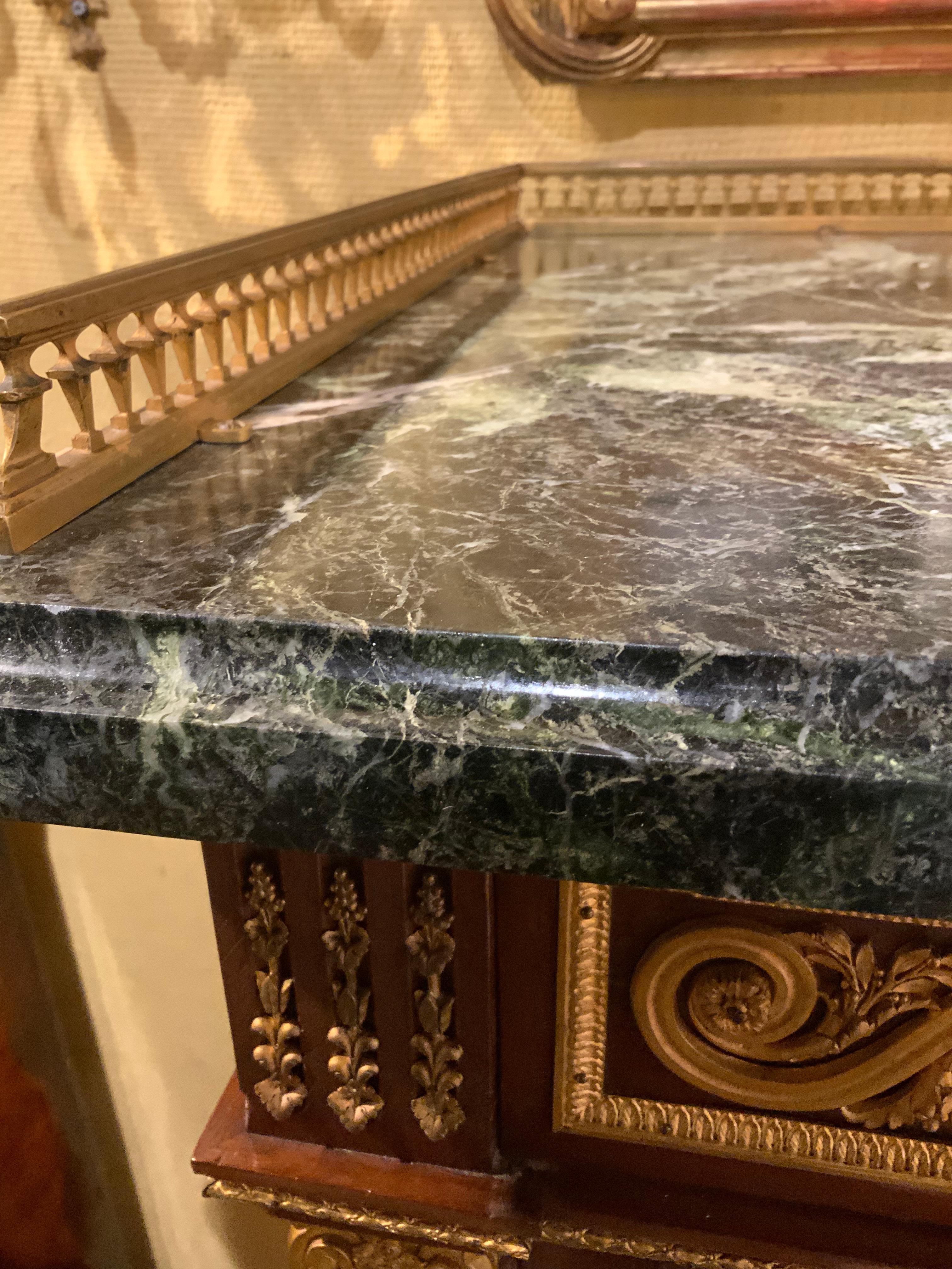 The exceptional cabinet work and the excellent bronze mounts
Make this piece special. It is made of mahogany and the
Workmanship is especially fine. It has a dark green marble top
With a gilt bronze gallery that runs down each side and
